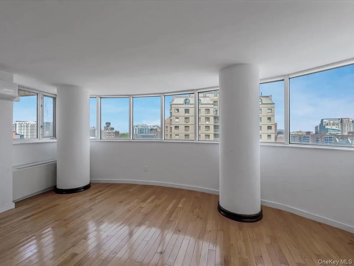 Unfurnished room featuring a city view, light wood-type flooring, and a wall mounted AC Unfurnished room featuring a city view, light wood-type flooring, and a wall mounted AC