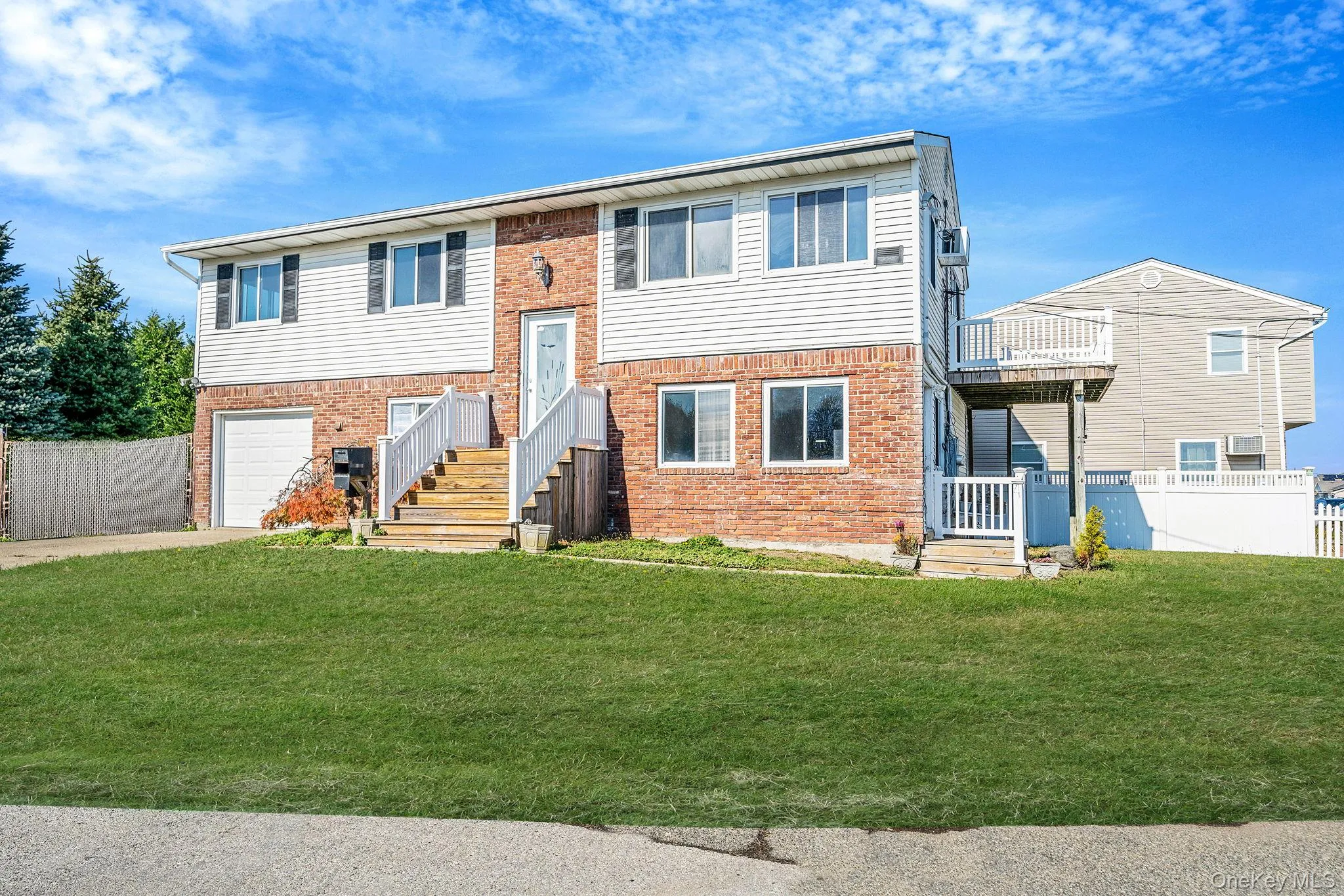 Bi-level home featuring brick siding, driveway, and an attached garage Bi-level home featuring brick siding, driveway, and an attached garage