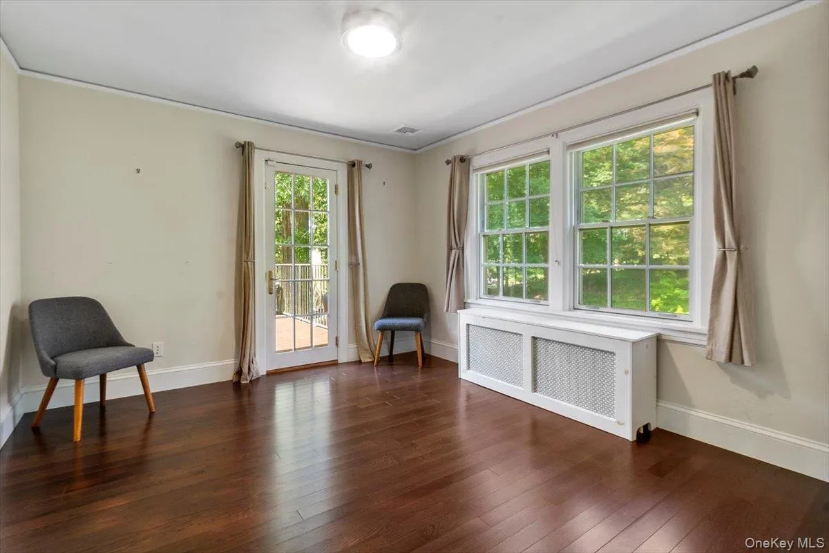 Living area with radiator and dark wood-type flooring Living area with radiator and dark wood-type flooring