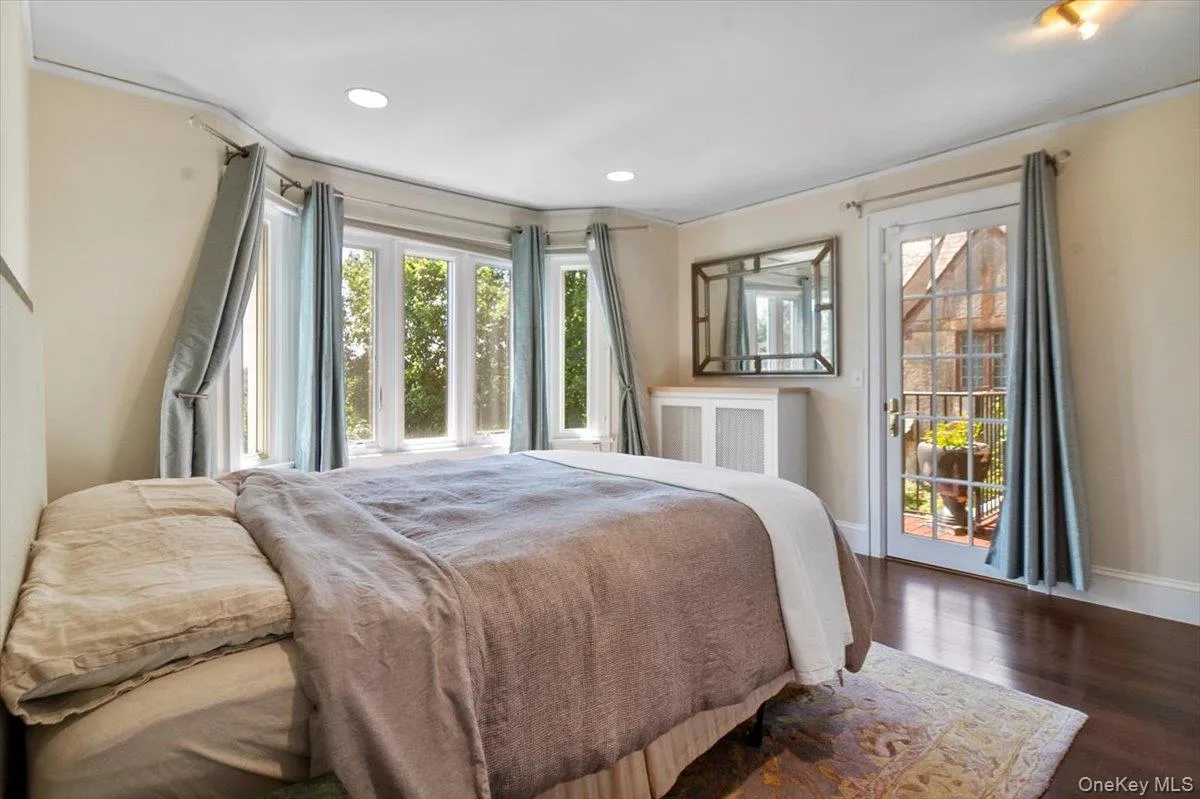 Bedroom with multiple windows, access to exterior, wood finished floors, and recessed lighting Bedroom with multiple windows, access to exterior, wood finished floors, and recessed lighting