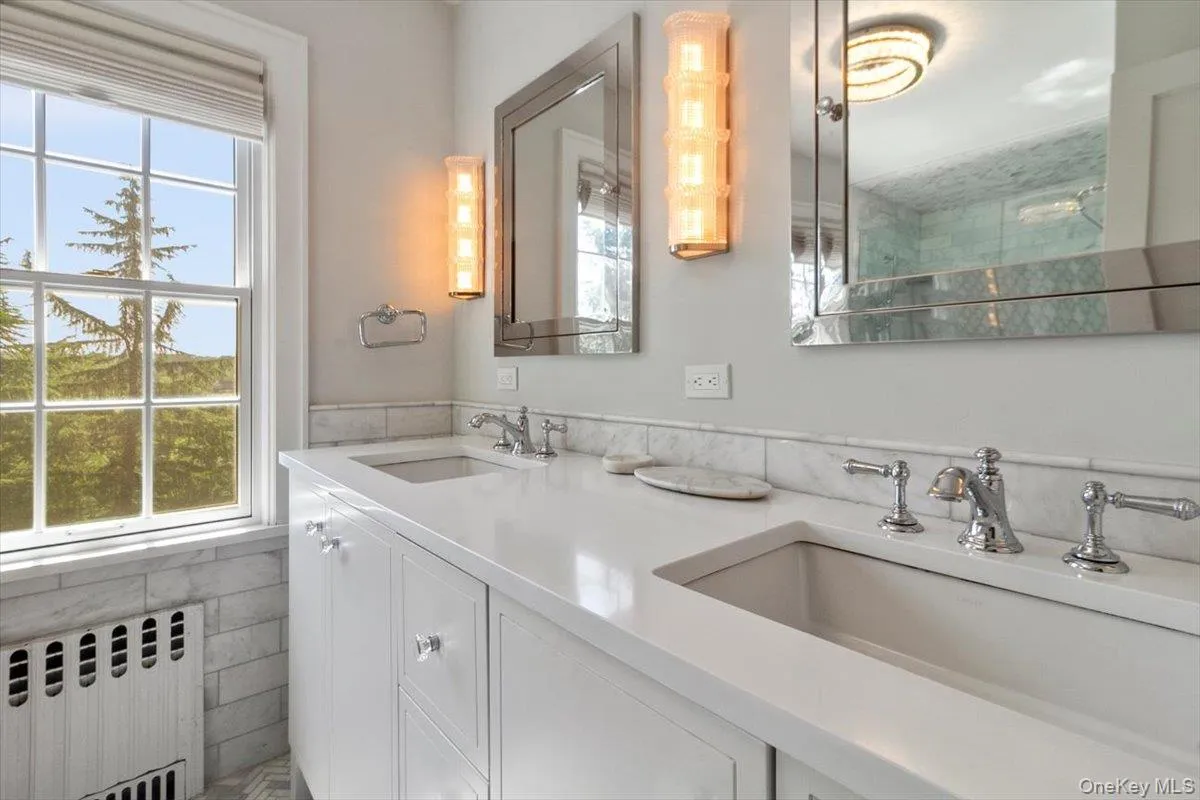 Bathroom featuring radiator heating unit, double vanity, and tile walls Bathroom featuring radiator heating unit, double vanity, and tile walls
