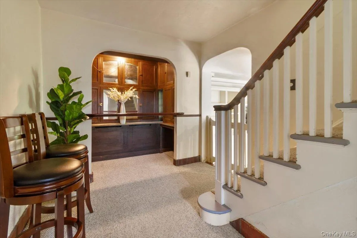Foyer entrance with carpet flooring, stairway, and arched walkways Foyer entrance with carpet flooring, stairway, and arched walkways