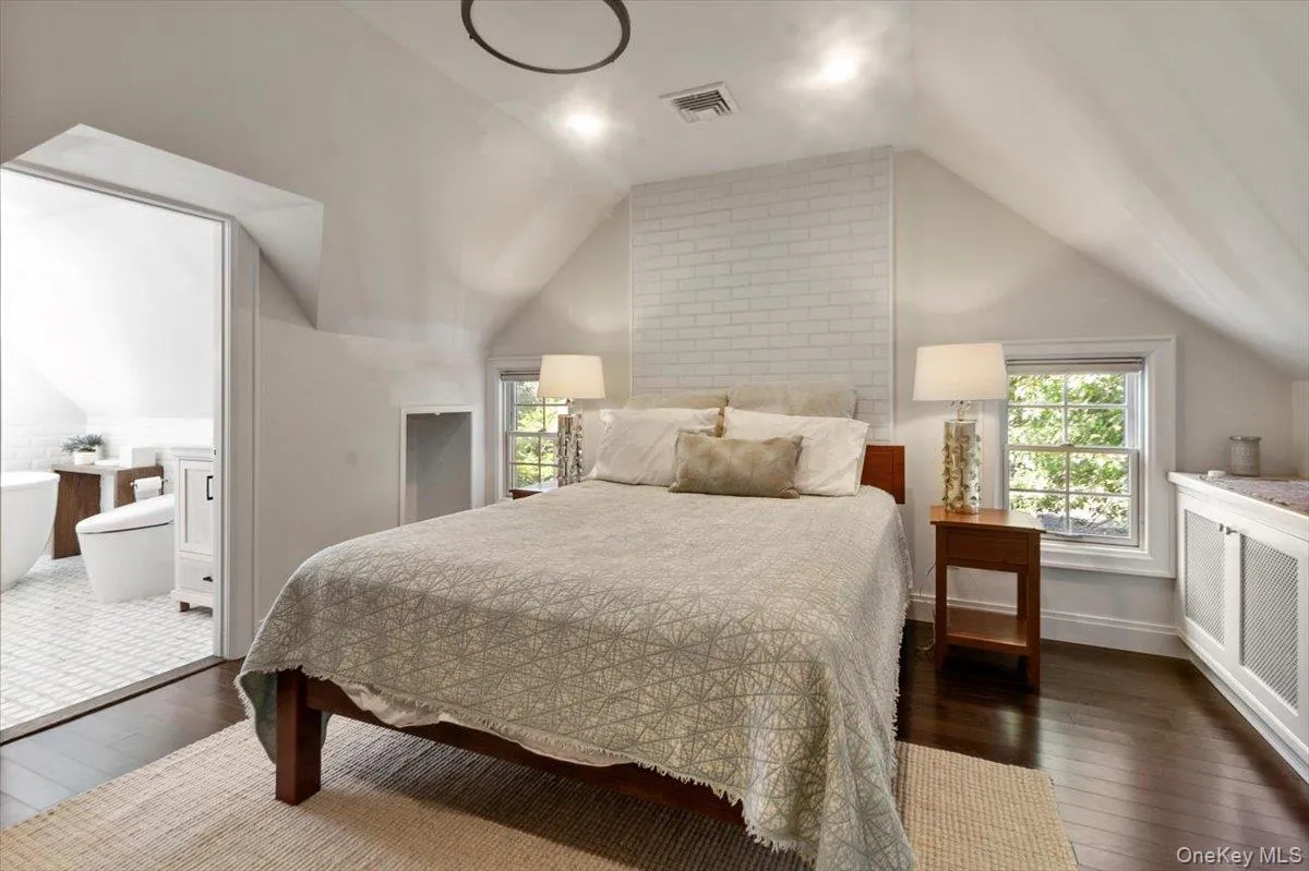 Bedroom with hardwood / wood-style floors and lofted ceiling Bedroom with hardwood / wood-style floors and lofted ceiling