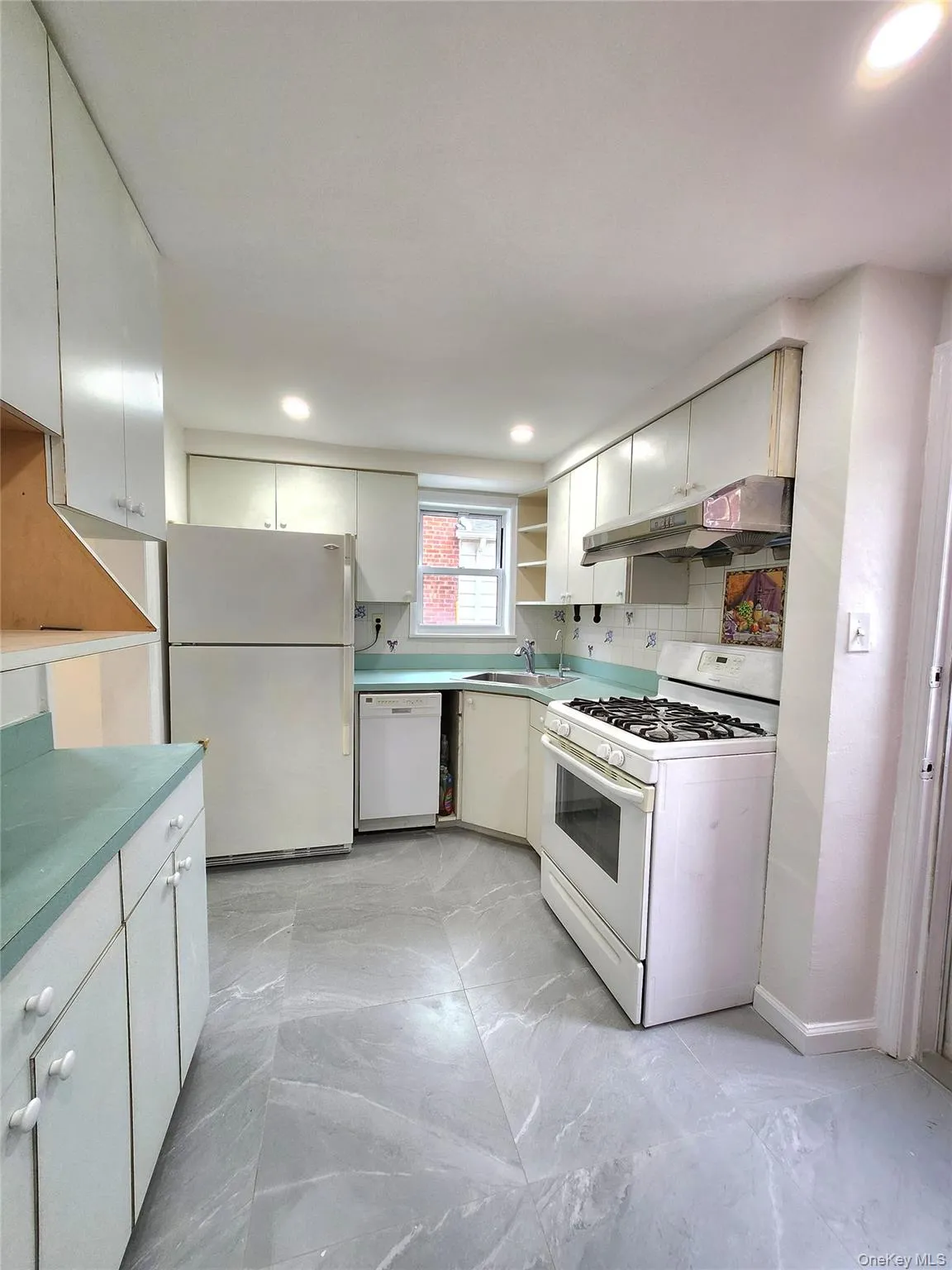 Kitchen with open shelves, white appliances, light marble finish flooring, under cabinet range hood, and decorative backsplash Kitchen with open shelves, white appliances, light marble finish flooring, under cabinet range hood, and decorative backsplash