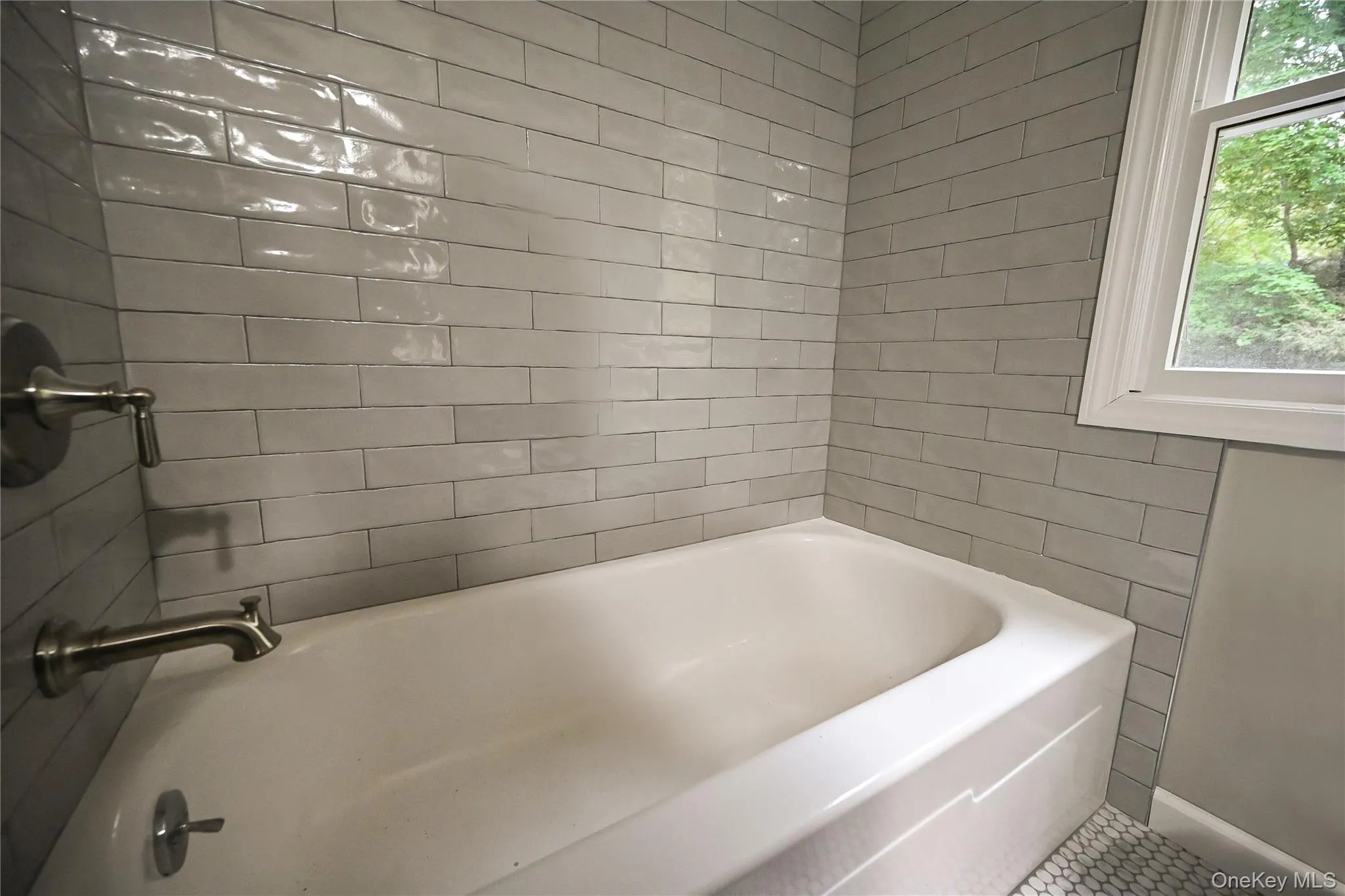 Full bathroom with a tub to relax in and tile walls Full bathroom with a tub to relax in and tile walls