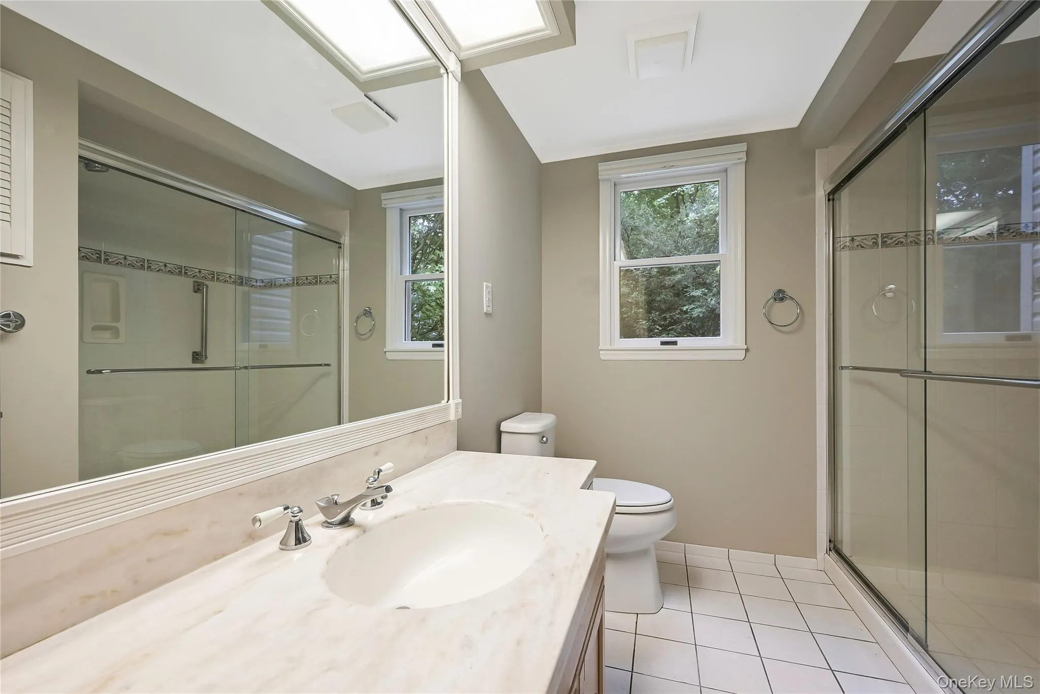 Bathroom with light tile patterned floors, a stall shower, and vanity Bathroom with light tile patterned floors, a stall shower, and vanity