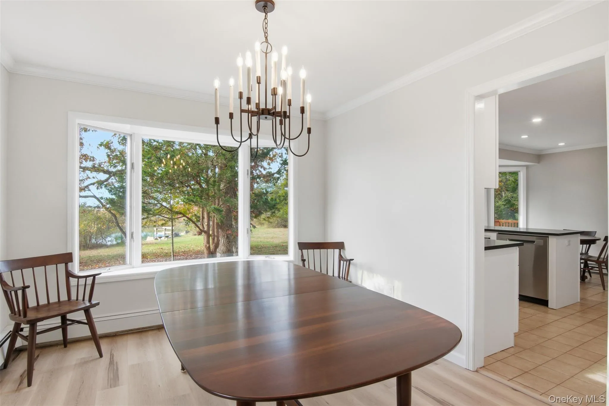 Dining space with crown molding, light wood-style floors, and a chandelier Dining space with crown molding, light wood-style floors, and a chandelier