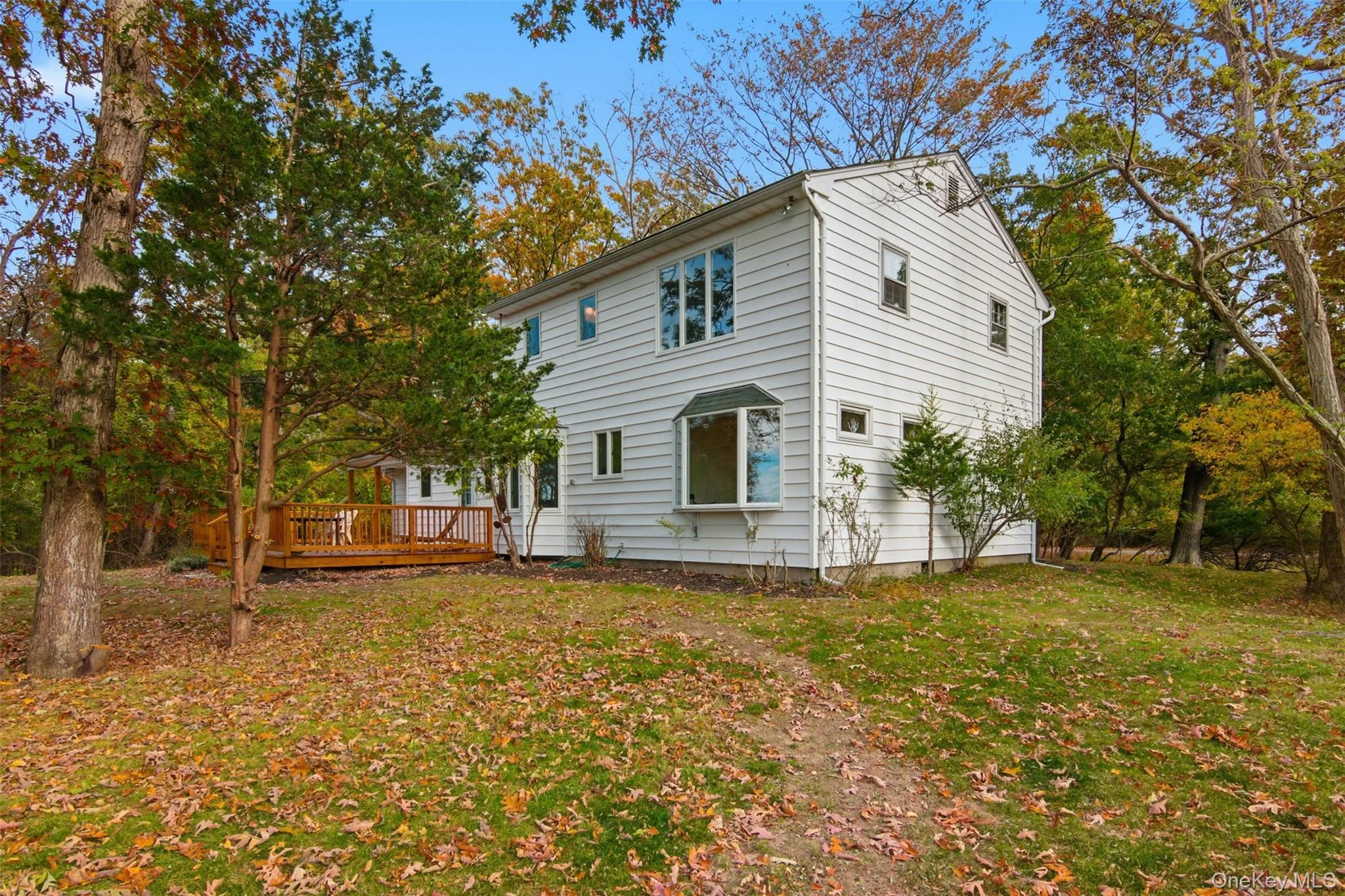 Rear view of property with a deck and a lawn Rear view of property with a deck and a lawn