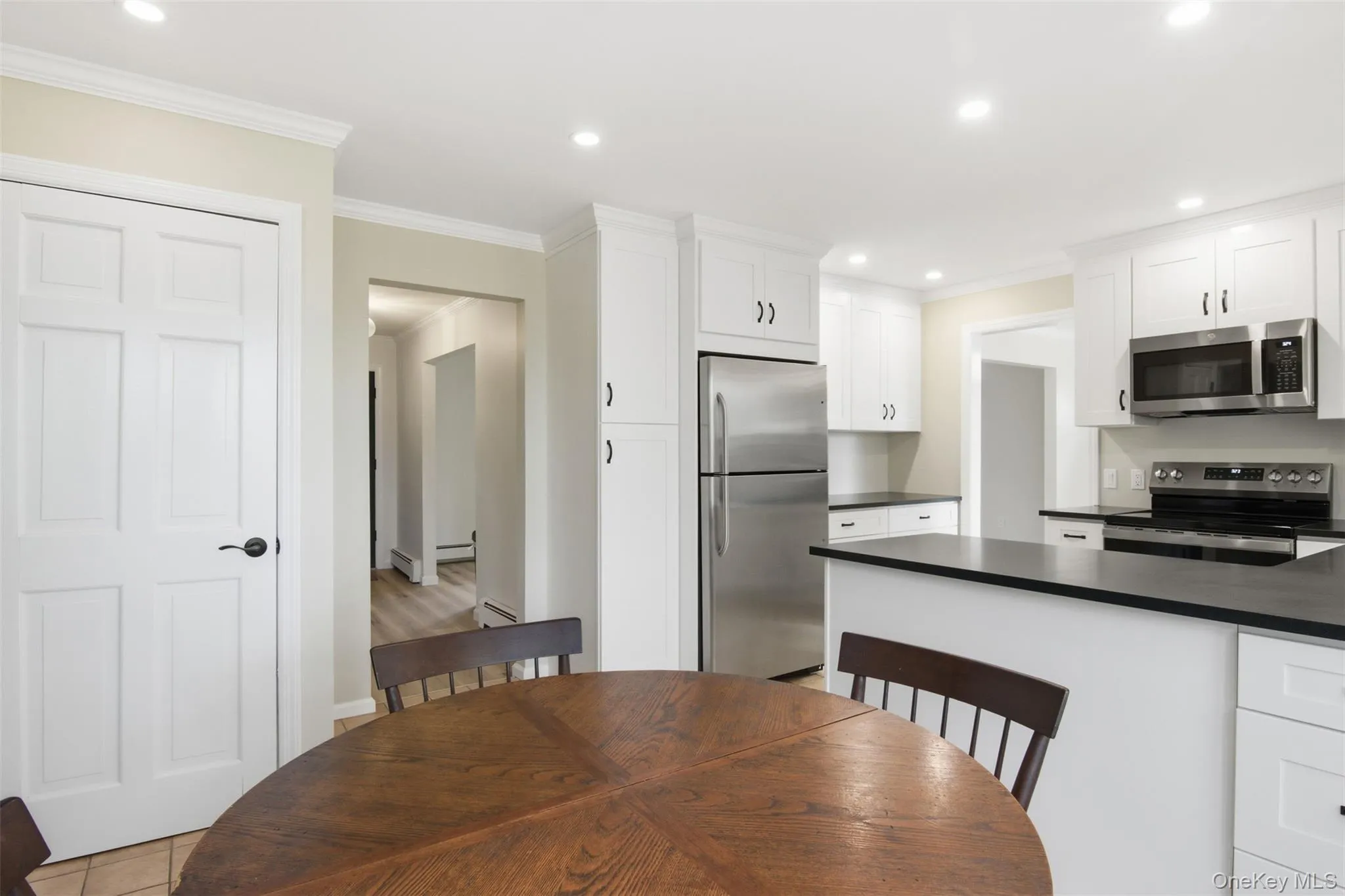 Dining room featuring recessed lighting, crown molding, and a baseboard radiator Dining room featuring recessed lighting, crown molding, and a baseboard radiator