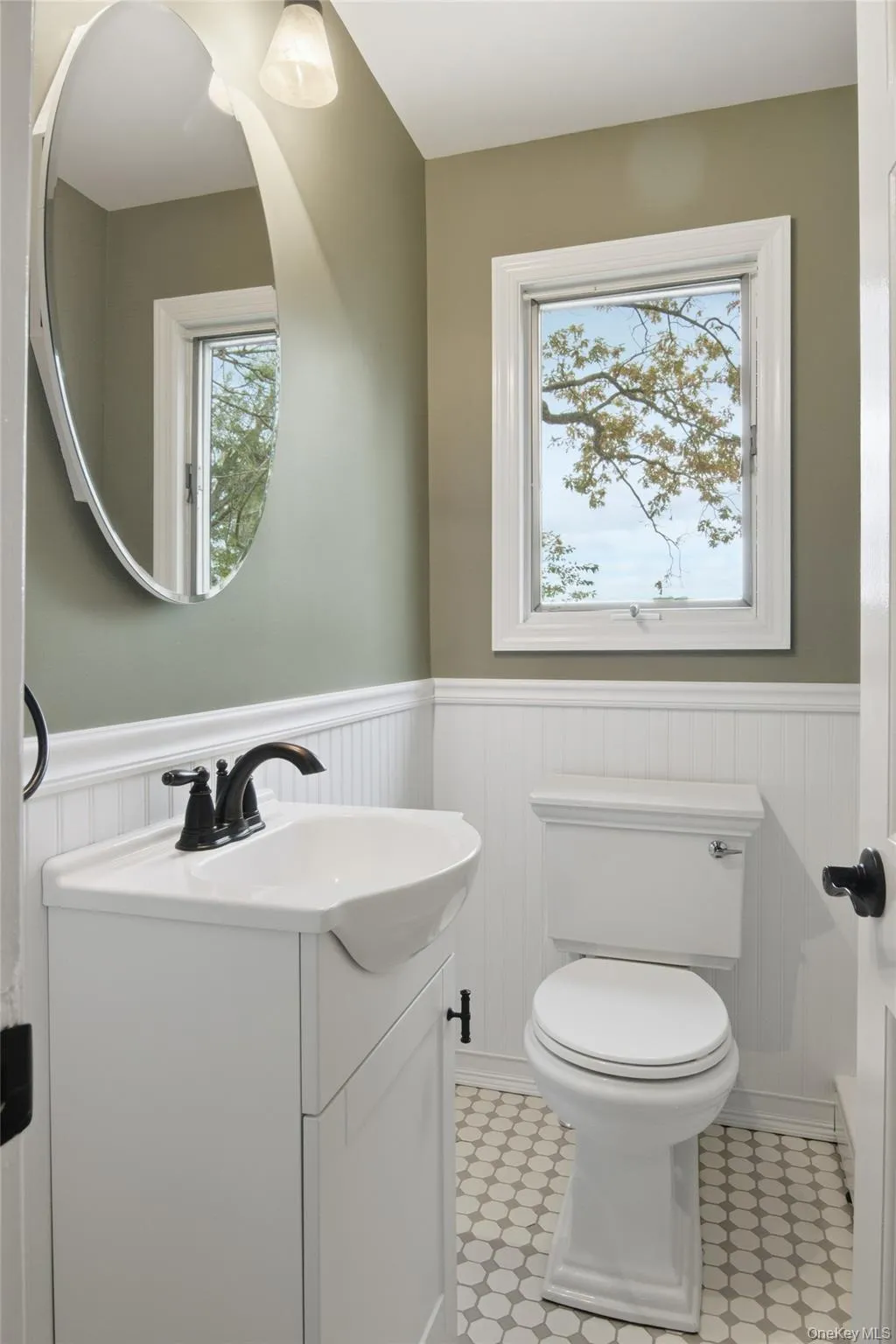 Half bathroom featuring wainscoting and vanity Half bathroom featuring wainscoting and vanity