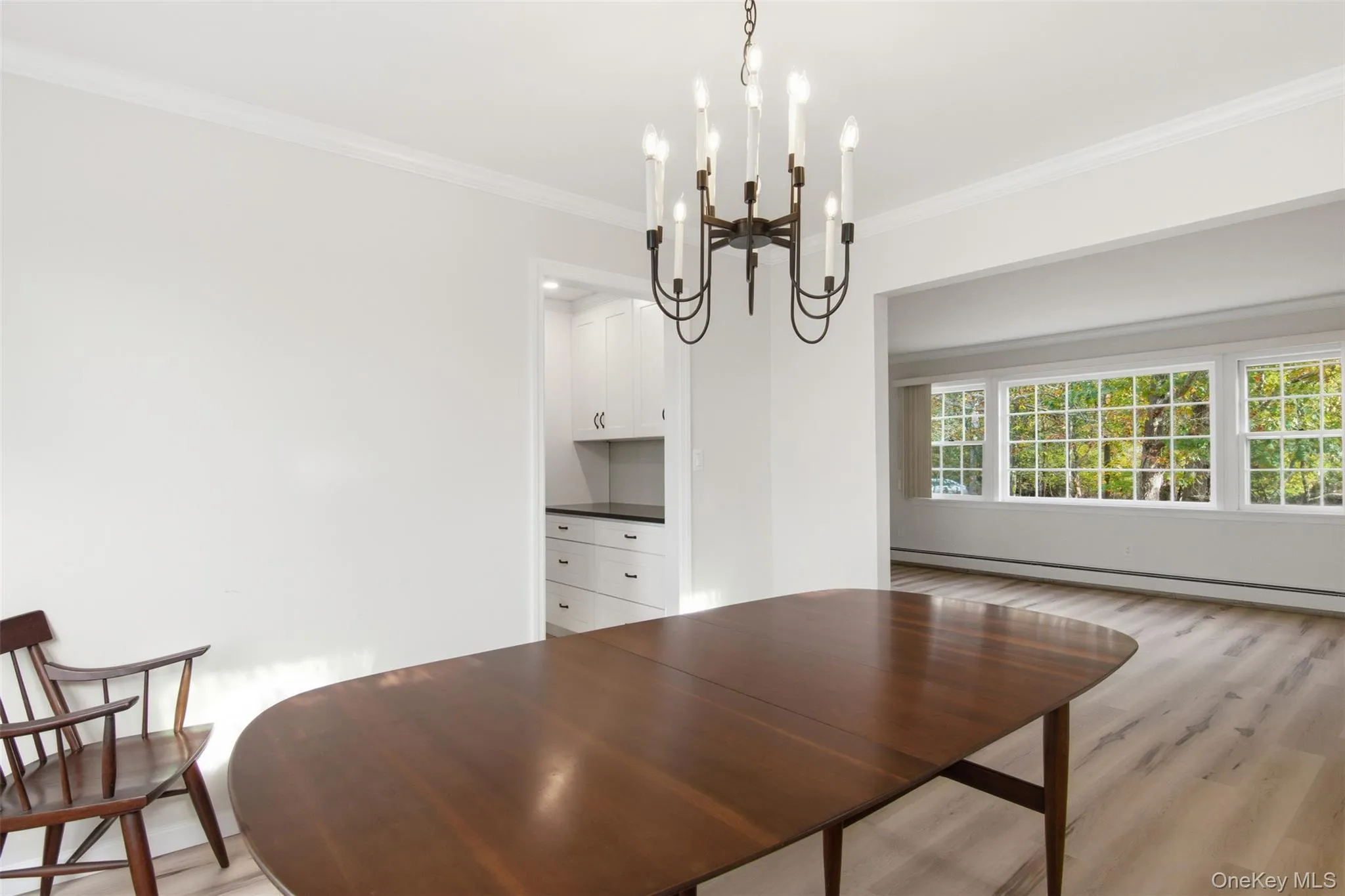 Dining area featuring crown molding, light wood-style flooring, and baseboard heating Dining area featuring crown molding, light wood-style flooring, and baseboard heating
