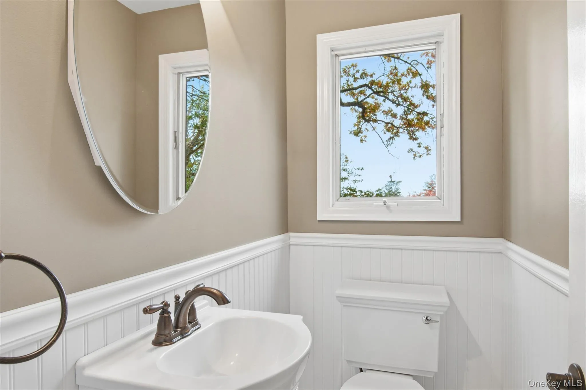 Bathroom featuring a wainscoted wall and toilet Bathroom featuring a wainscoted wall and toilet