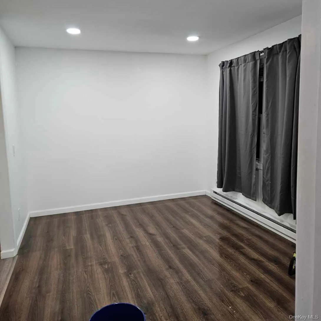Unfurnished room featuring a baseboard heating unit, dark wood finished floors, and recessed lighting Unfurnished room featuring a baseboard heating unit, dark wood finished floors, and recessed lighting