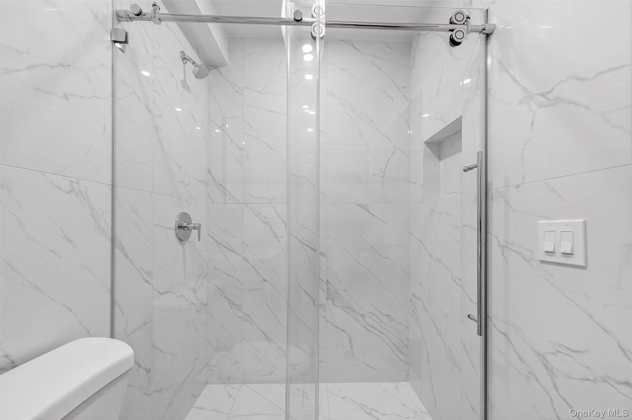 Full bath with toilet and a marble finish shower Full bath with toilet and a marble finish shower