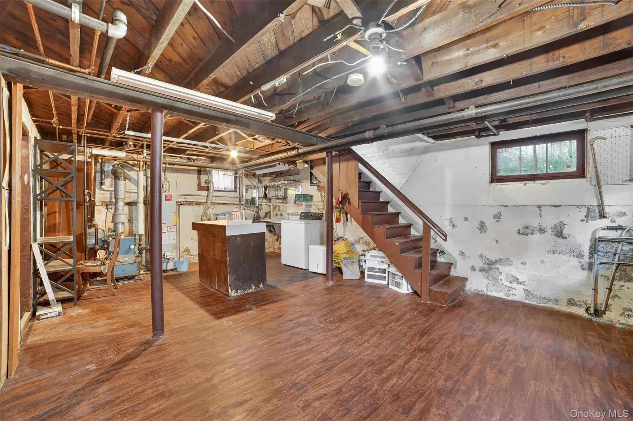 Basement featuring stairway, dark wood-style floors, washer / clothes dryer, and gas water heater Basement featuring stairway, dark wood-style floors, washer / clothes dryer, and gas water heater