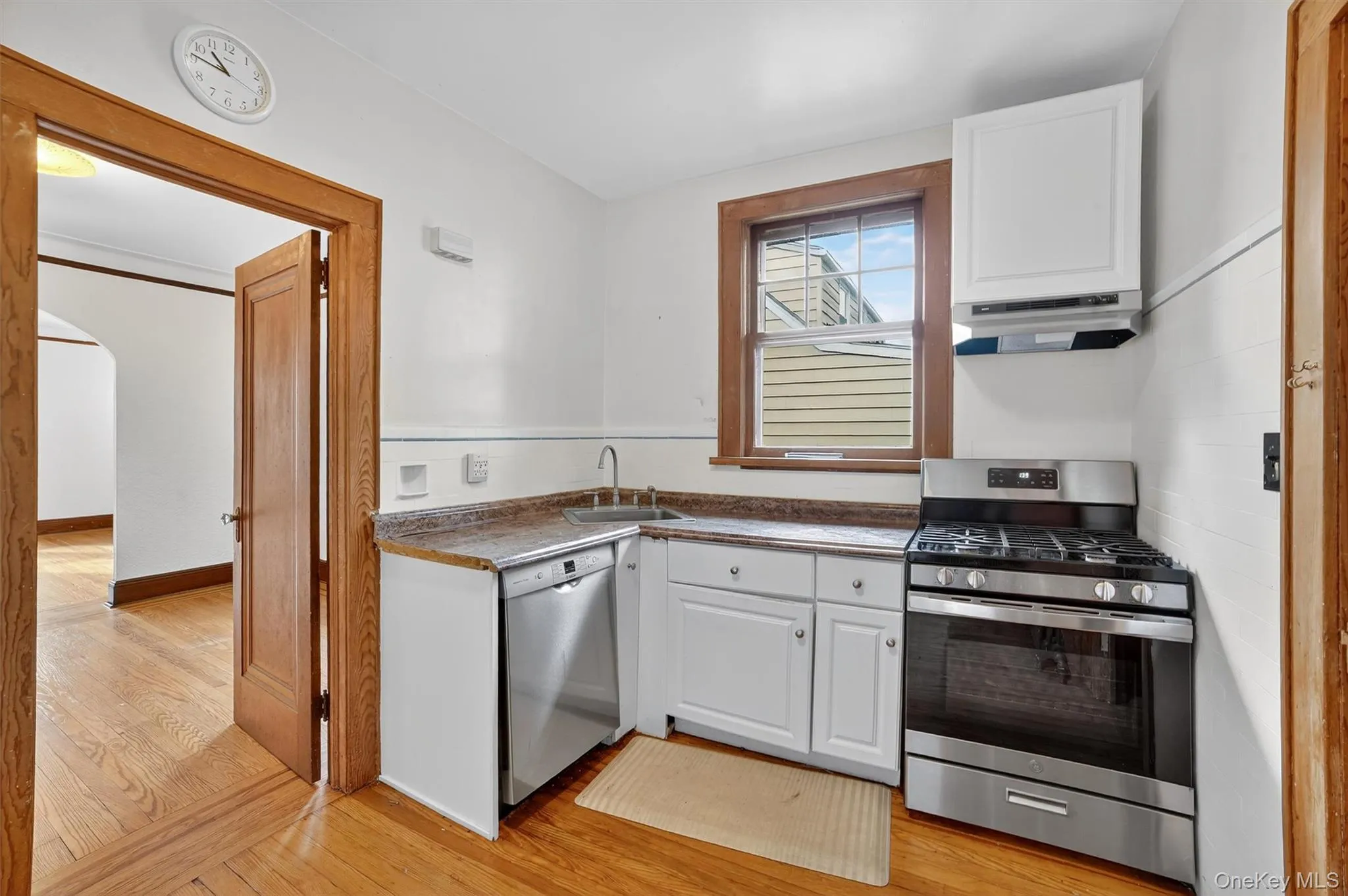 Kitchen with appliances with stainless steel finishes, white cabinets, and light wood-style flooring Kitchen with appliances with stainless steel finishes, white cabinets, and light wood-style flooring
