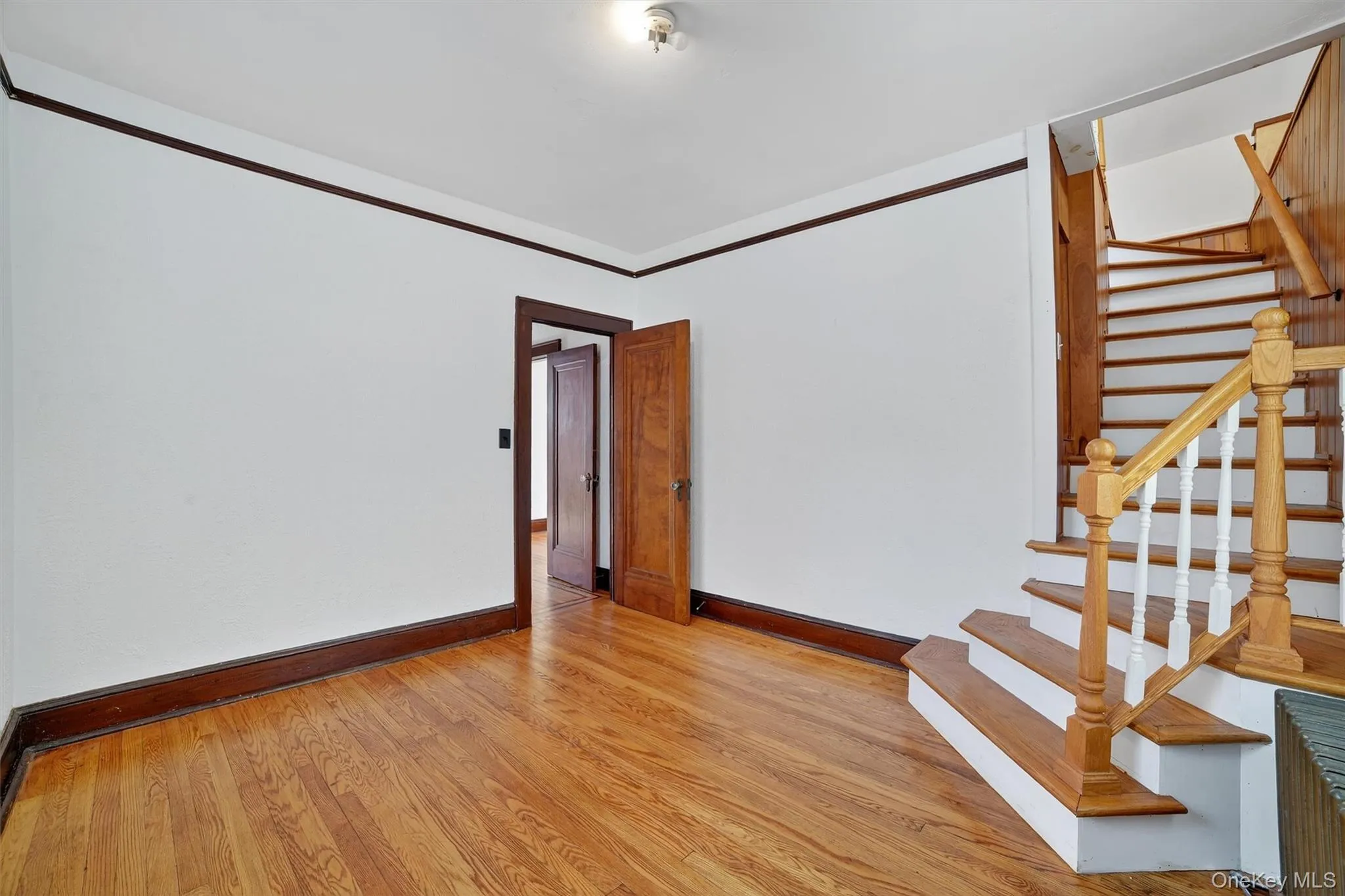 Spare room featuring light wood finished floors and stairs Spare room featuring light wood finished floors and stairs
