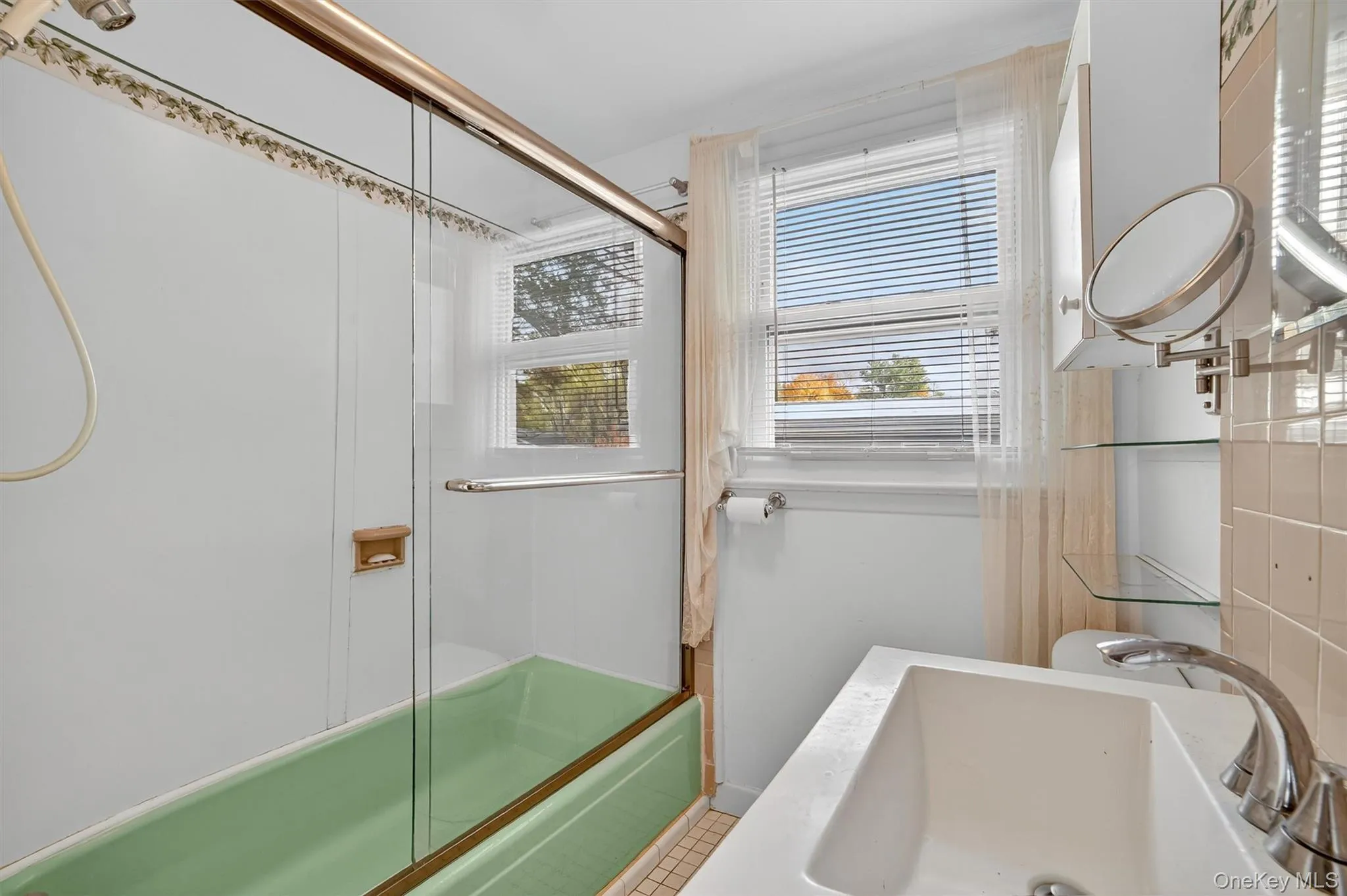 Full bathroom featuring enclosed tub / shower combo, light tile patterned flooring, and vanity Full bathroom featuring enclosed tub / shower combo, light tile patterned flooring, and vanity