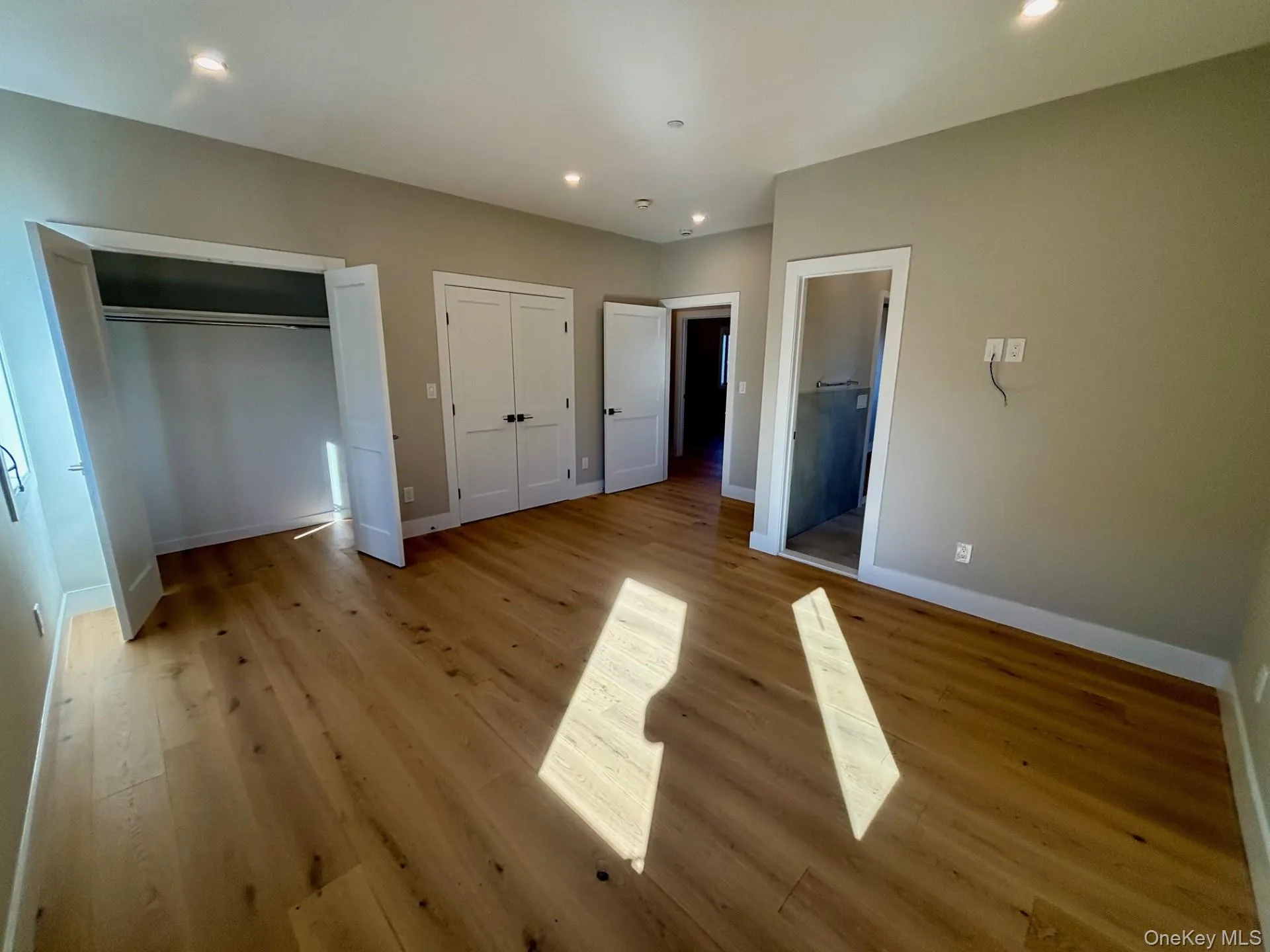 Unfurnished bedroom with two closets, light wood-type flooring, and recessed lighting Unfurnished bedroom with two closets, light wood-type flooring, and recessed lighting