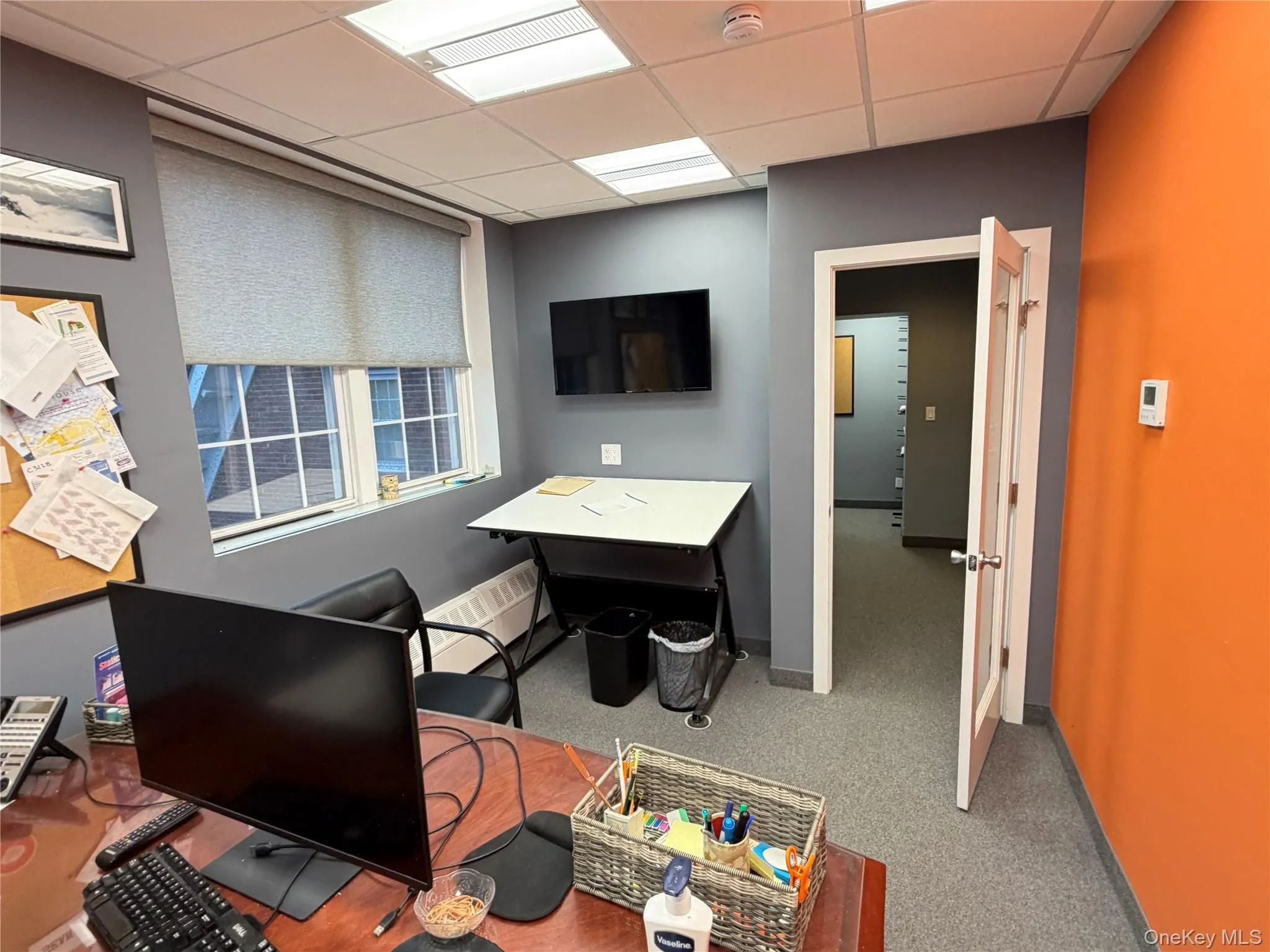 Office area featuring a paneled ceiling and light carpet Office area featuring a paneled ceiling and light carpet
