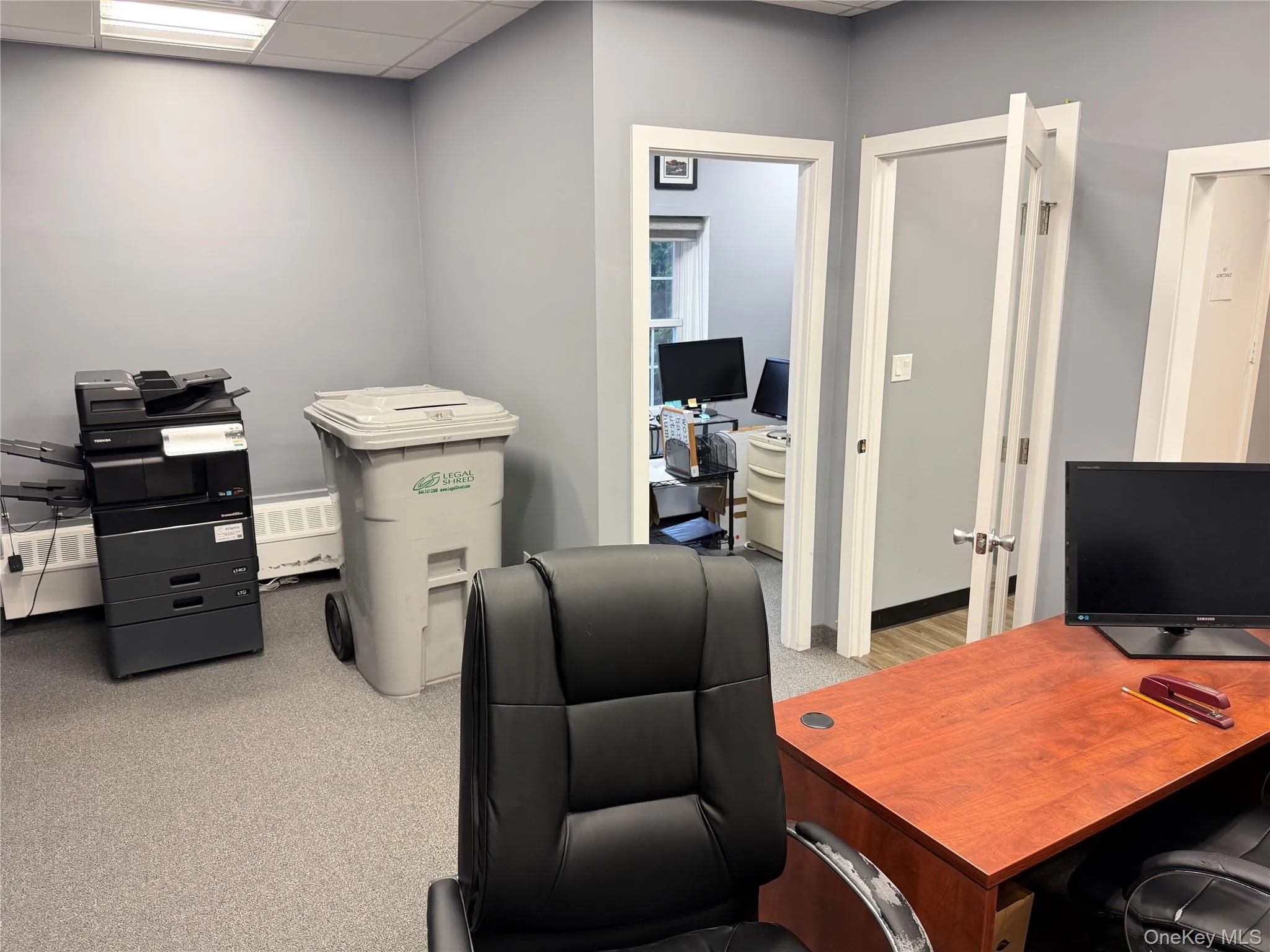 Office area with a paneled ceiling and light colored carpet Office area with a paneled ceiling and light colored carpet