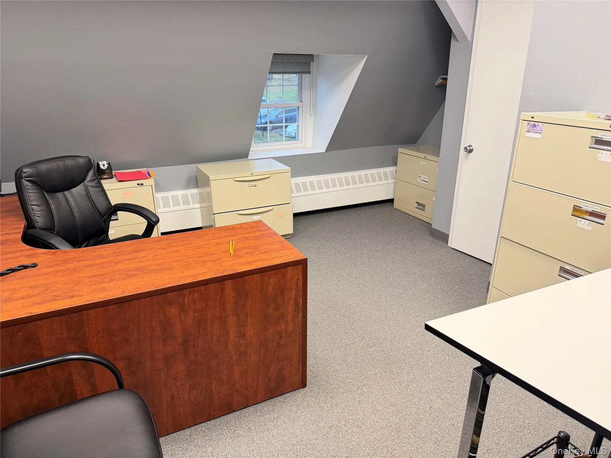 Office with light colored carpet, vaulted ceiling, and a baseboard radiator Office with light colored carpet, vaulted ceiling, and a baseboard radiator