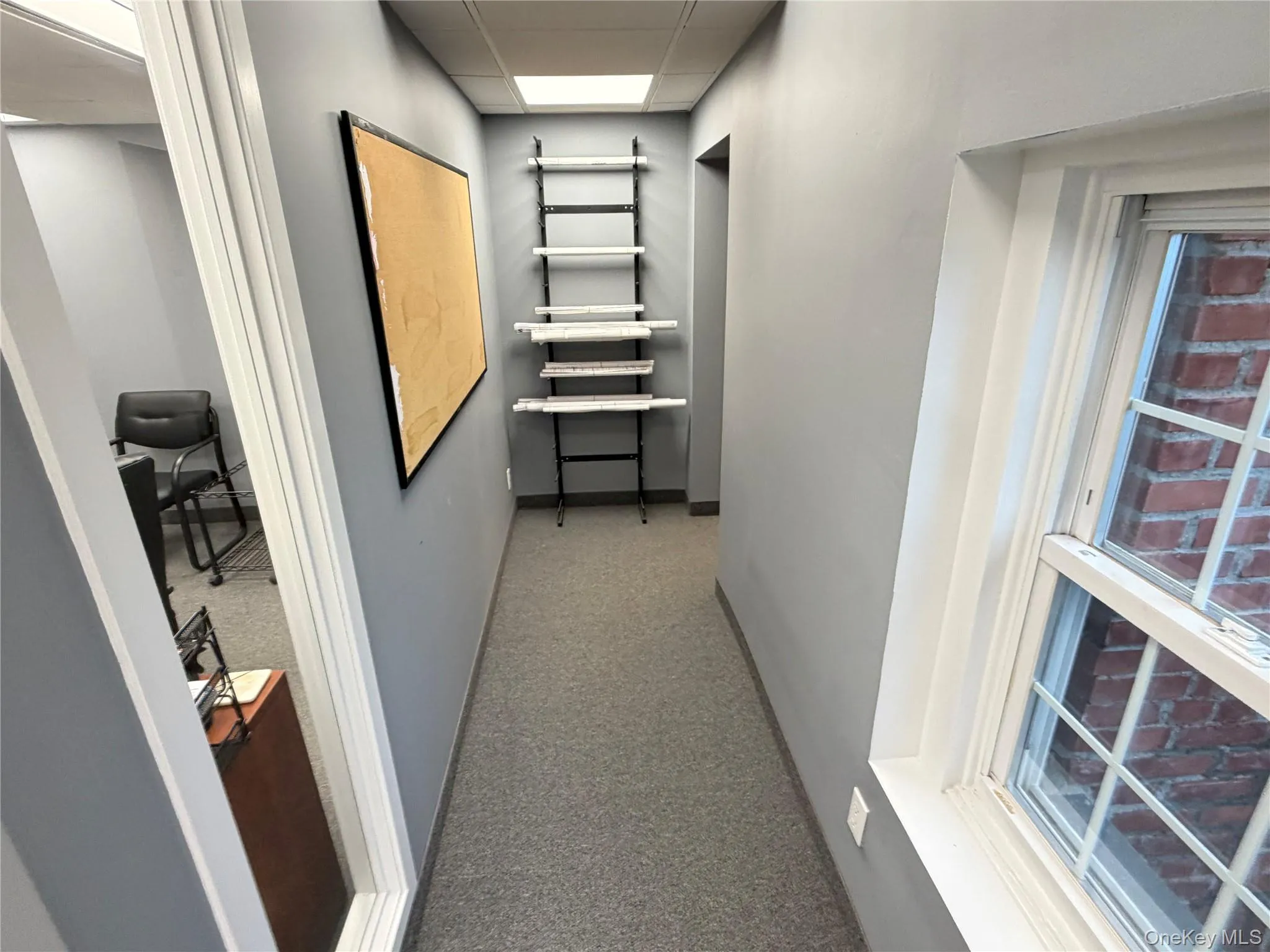 Hall with a drop ceiling and baseboards Hall with a drop ceiling and baseboards