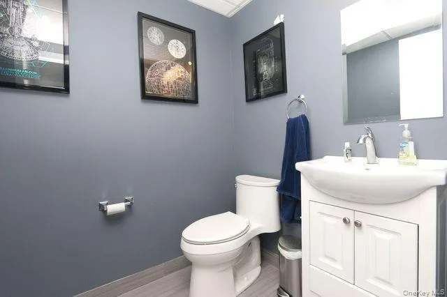 Half bath featuring vanity and wood finished floors Half bath featuring vanity and wood finished floors