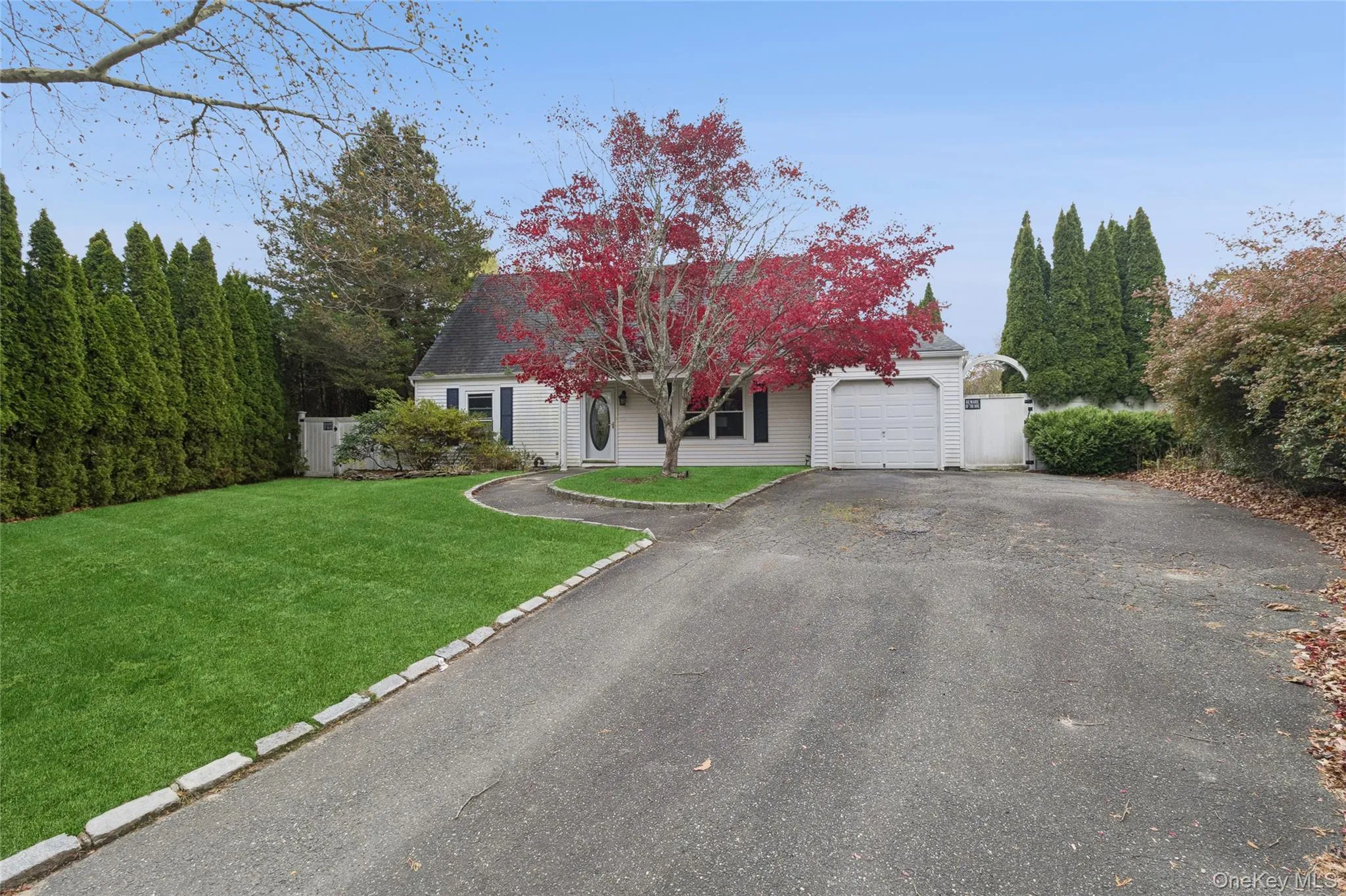 View of front facade featuring a front yard, driveway, and a garage View of front facade featuring a front yard, driveway, and a garage