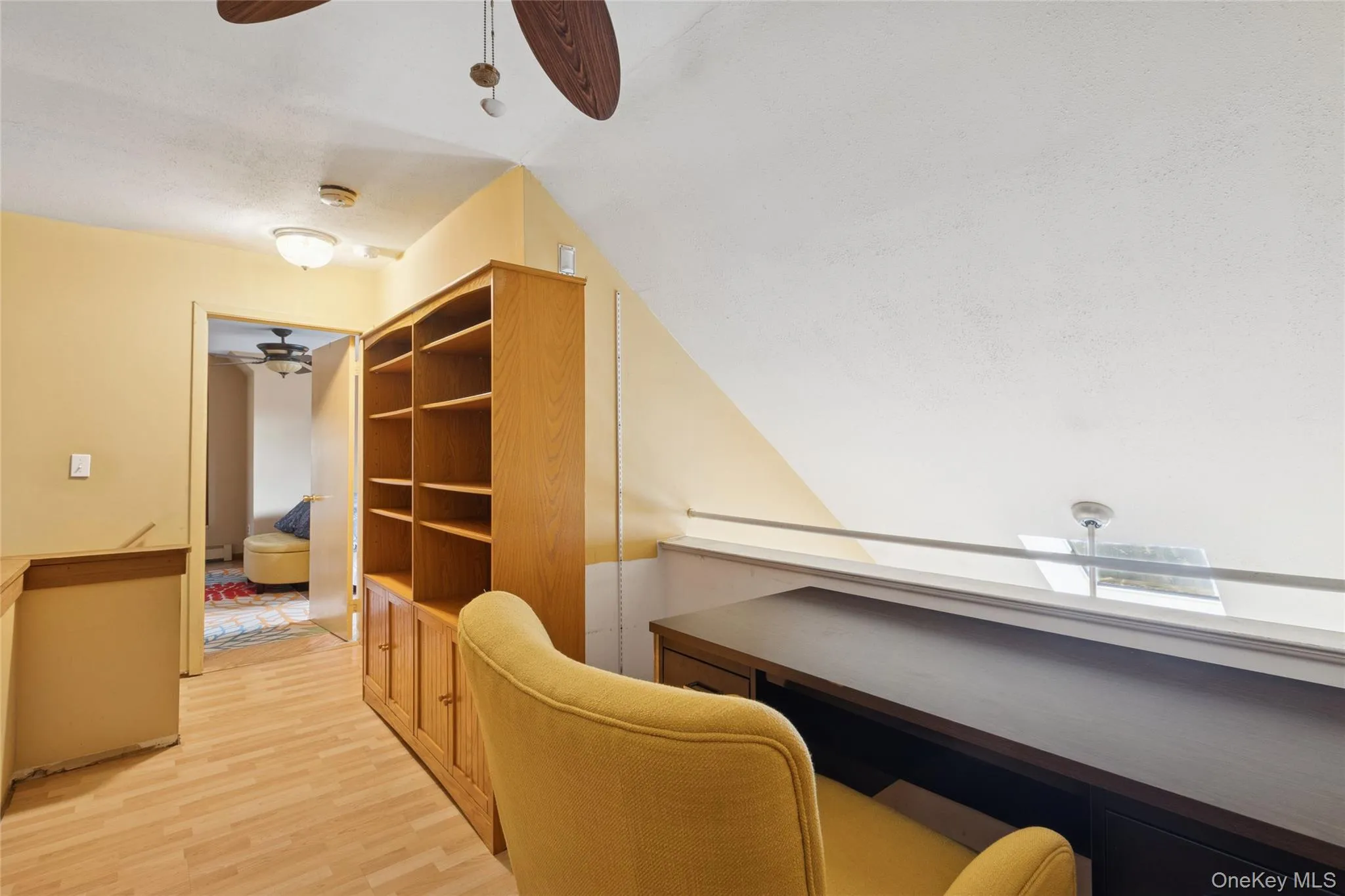 Home office with a ceiling fan, light wood-style floors, and lofted ceiling Home office with a ceiling fan, light wood-style floors, and lofted ceiling