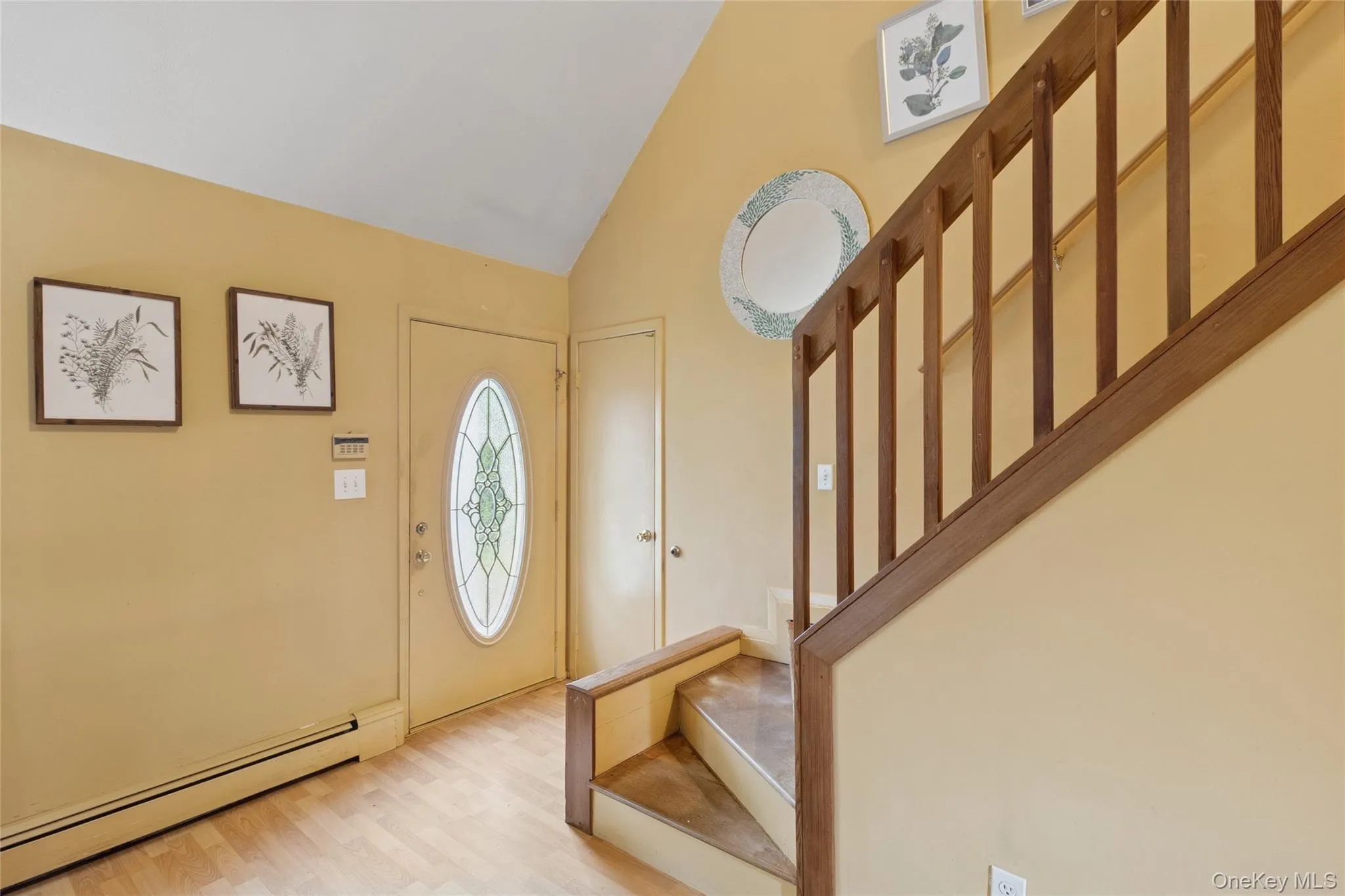 Foyer with baseboard heating, stairway, light wood finished floors, and high vaulted ceiling Foyer with baseboard heating, stairway, light wood finished floors, and high vaulted ceiling