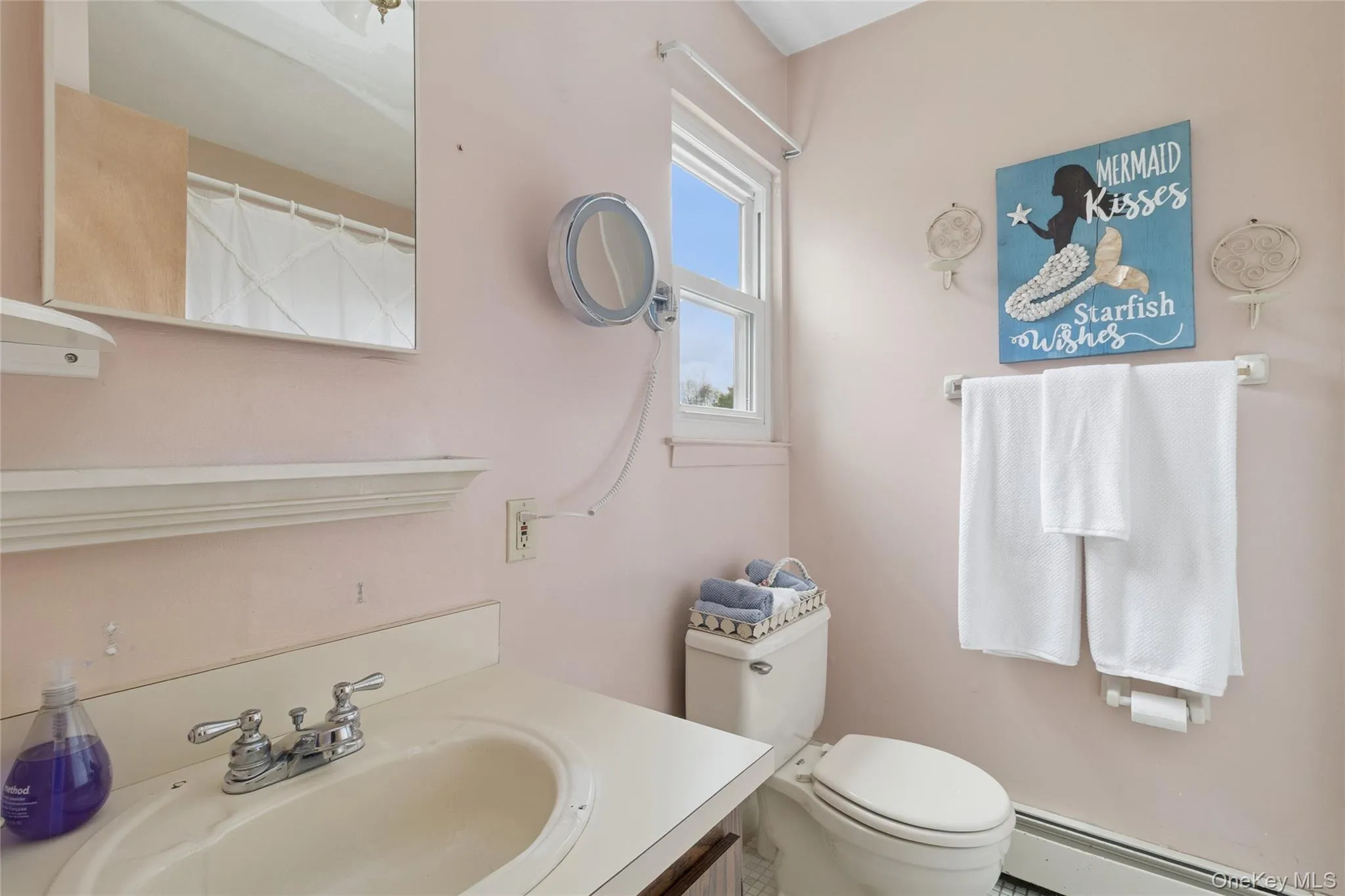 Bathroom featuring vanity, baseboard heating, and curtained shower Bathroom featuring vanity, baseboard heating, and curtained shower