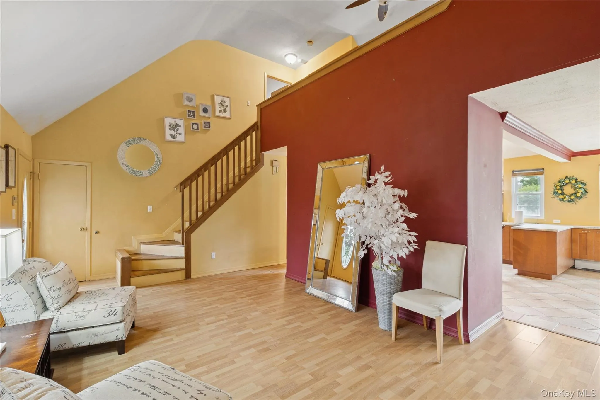Living area with light wood-style flooring, stairway, and high vaulted ceiling Living area with light wood-style flooring, stairway, and high vaulted ceiling