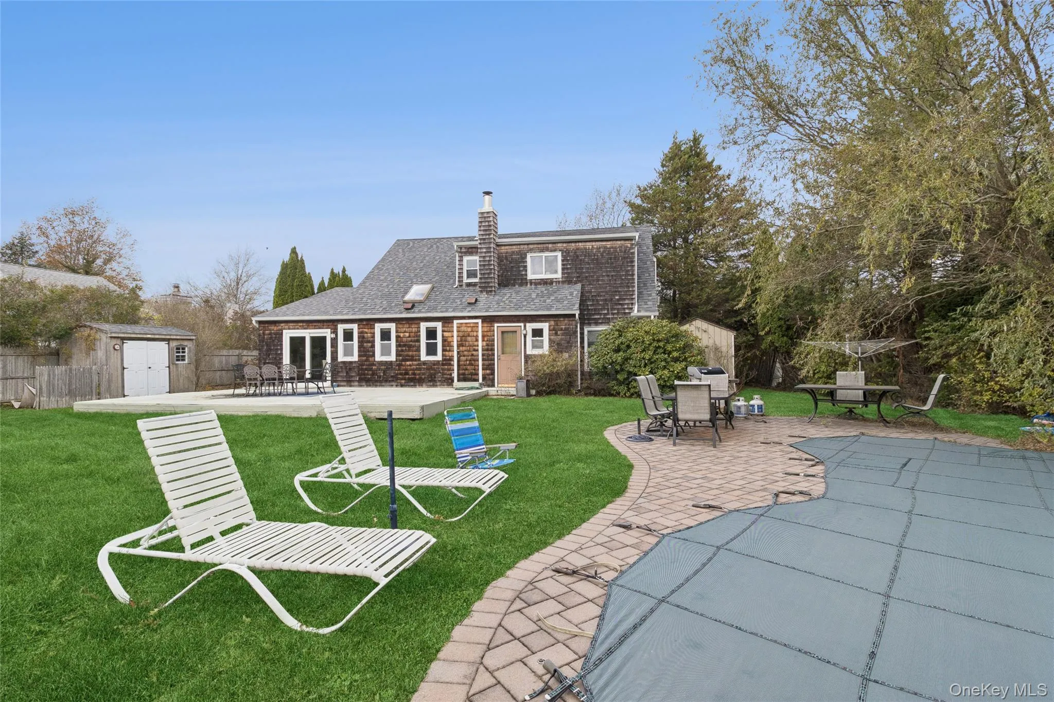 Back of house featuring a patio, a storage unit, a chimney, and outdoor dining area Back of house featuring a patio, a storage unit, a chimney, and outdoor dining area