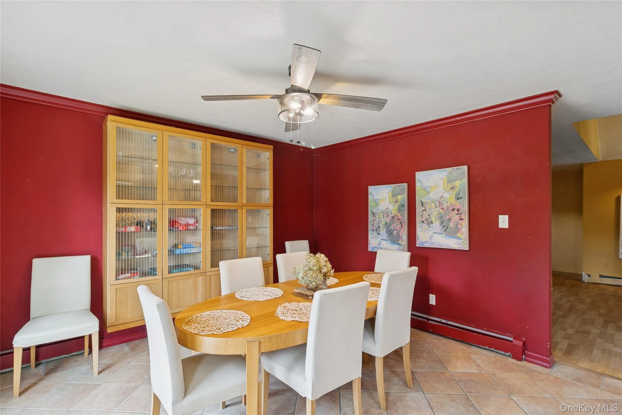 Dining room with a baseboard radiator, light tile patterned flooring, a ceiling fan, and ornamental molding Dining room with a baseboard radiator, light tile patterned flooring, a ceiling fan, and ornamental molding