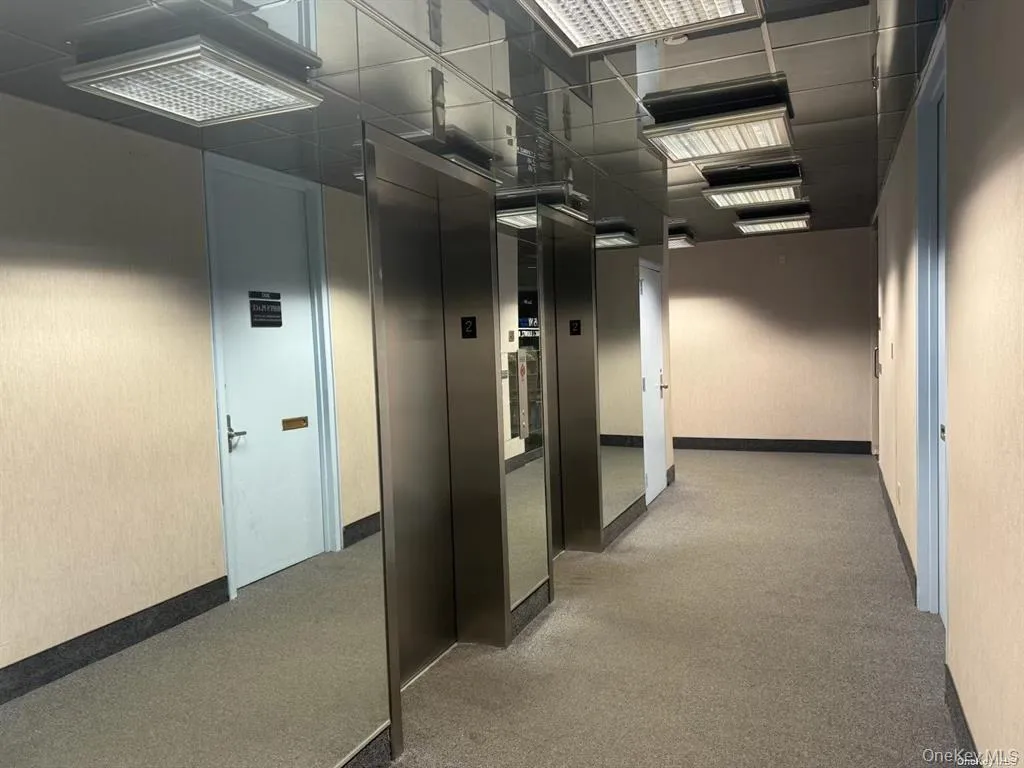 Hall featuring elevator and carpet Hall featuring elevator and carpet