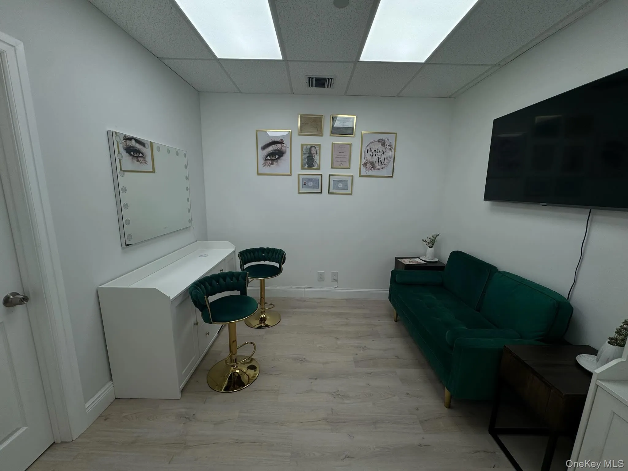 Living area featuring light wood-style floors and a paneled ceiling Living area featuring light wood-style floors and a paneled ceiling