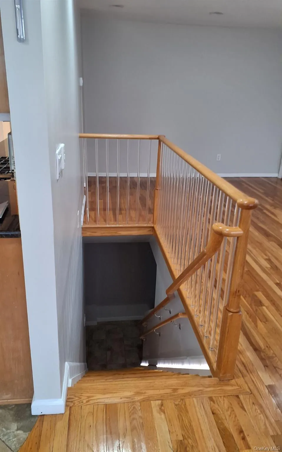 Stairway featuring hardwood / wood-style floors and baseboards Stairway featuring hardwood / wood-style floors and baseboards