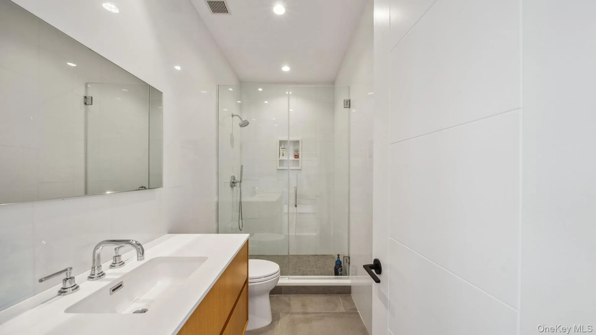 Bathroom with a shower stall, vanity, and recessed lighting Bathroom with a shower stall, vanity, and recessed lighting
