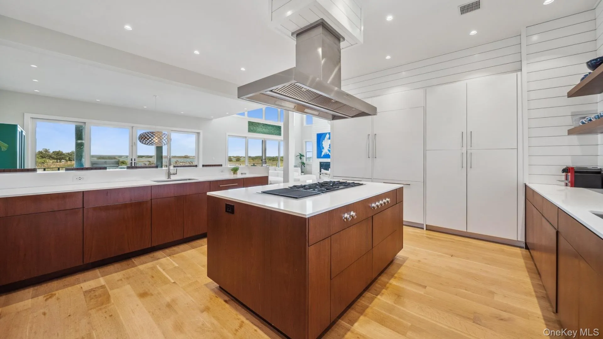 Kitchen featuring open shelves, a kitchen island, light wood finished floors, recessed lighting, and modern cabinets Kitchen featuring open shelves, a kitchen island, light wood finished floors, recessed lighting, and modern cabinets