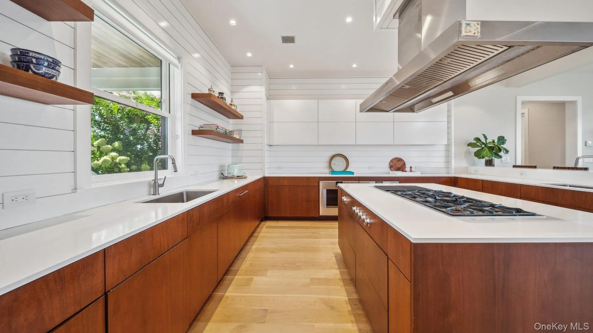 Kitchen featuring open shelves, brown cabinetry, light wood finished floors, modern cabinets, and extractor fan Kitchen featuring open shelves, brown cabinetry, light wood finished floors, modern cabinets, and extractor fan