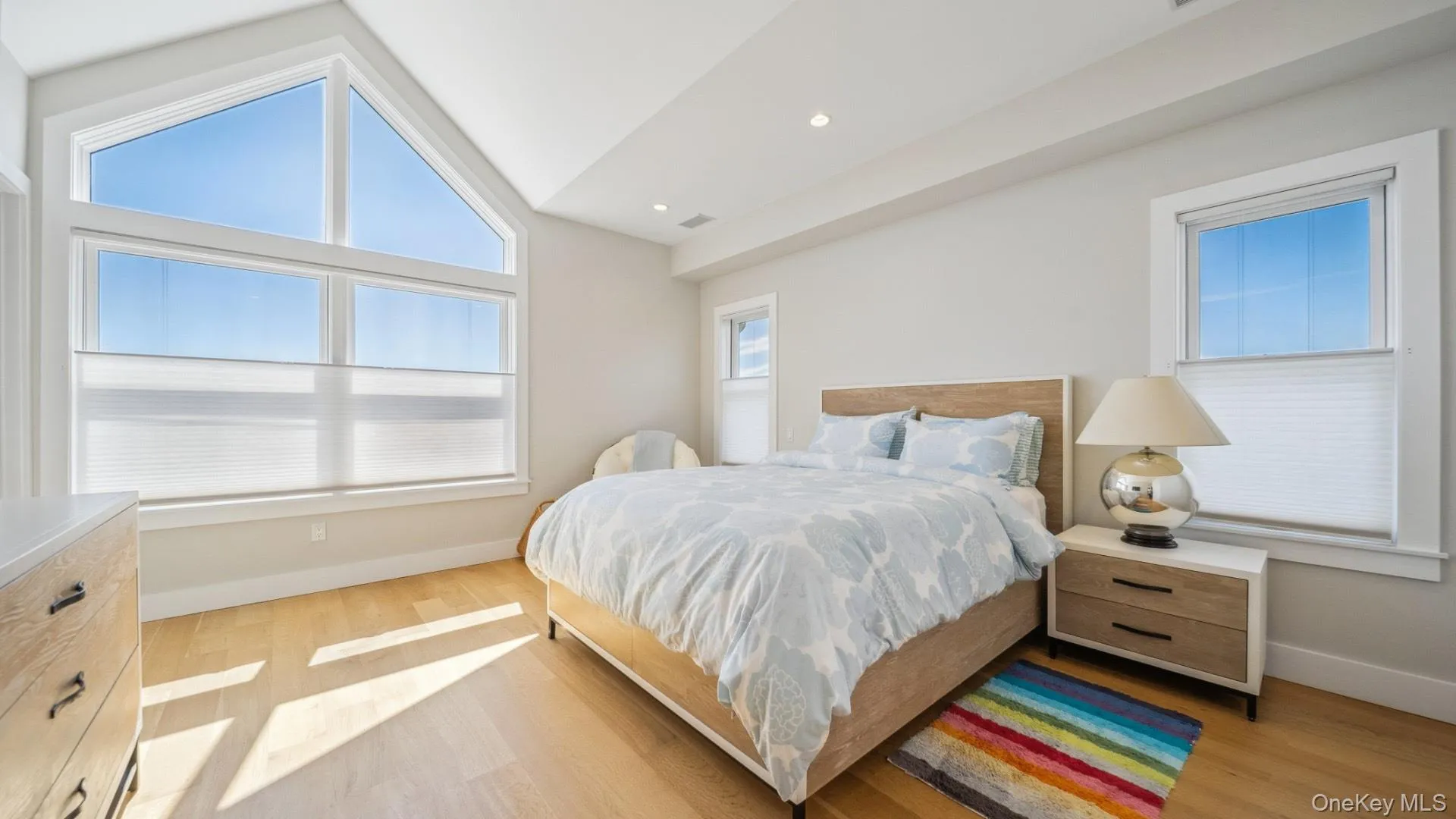 Bedroom with vaulted ceiling, light wood finished floors, and recessed lighting Bedroom with vaulted ceiling, light wood finished floors, and recessed lighting