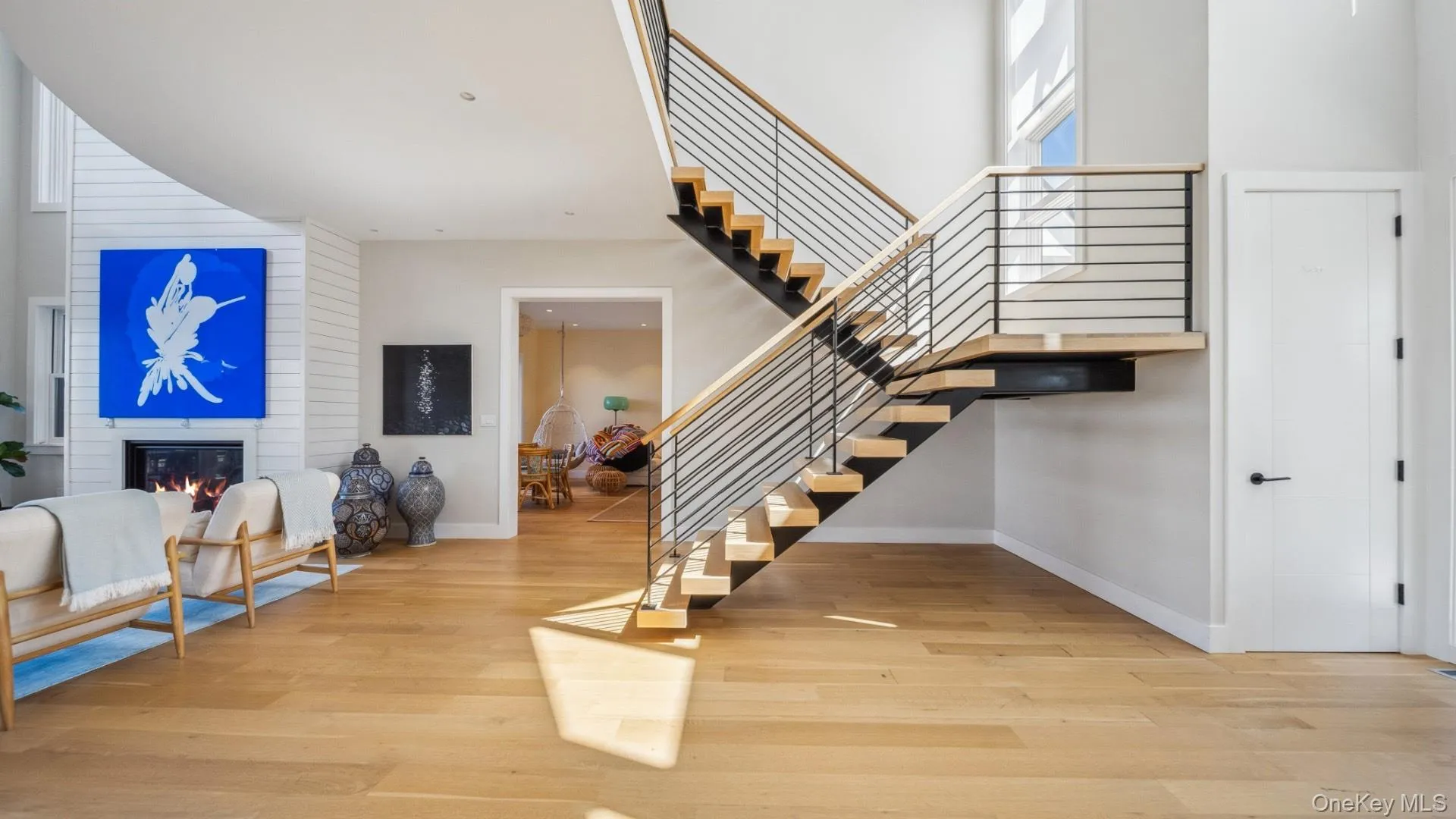 Stairs with a towering ceiling, a fireplace, and wood finished floors Stairs with a towering ceiling, a fireplace, and wood finished floors