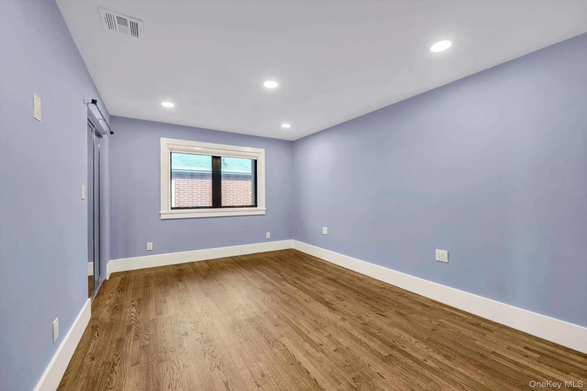 Spare room featuring a barn door, wood finished floors, and recessed lighting Spare room featuring a barn door, wood finished floors, and recessed lighting