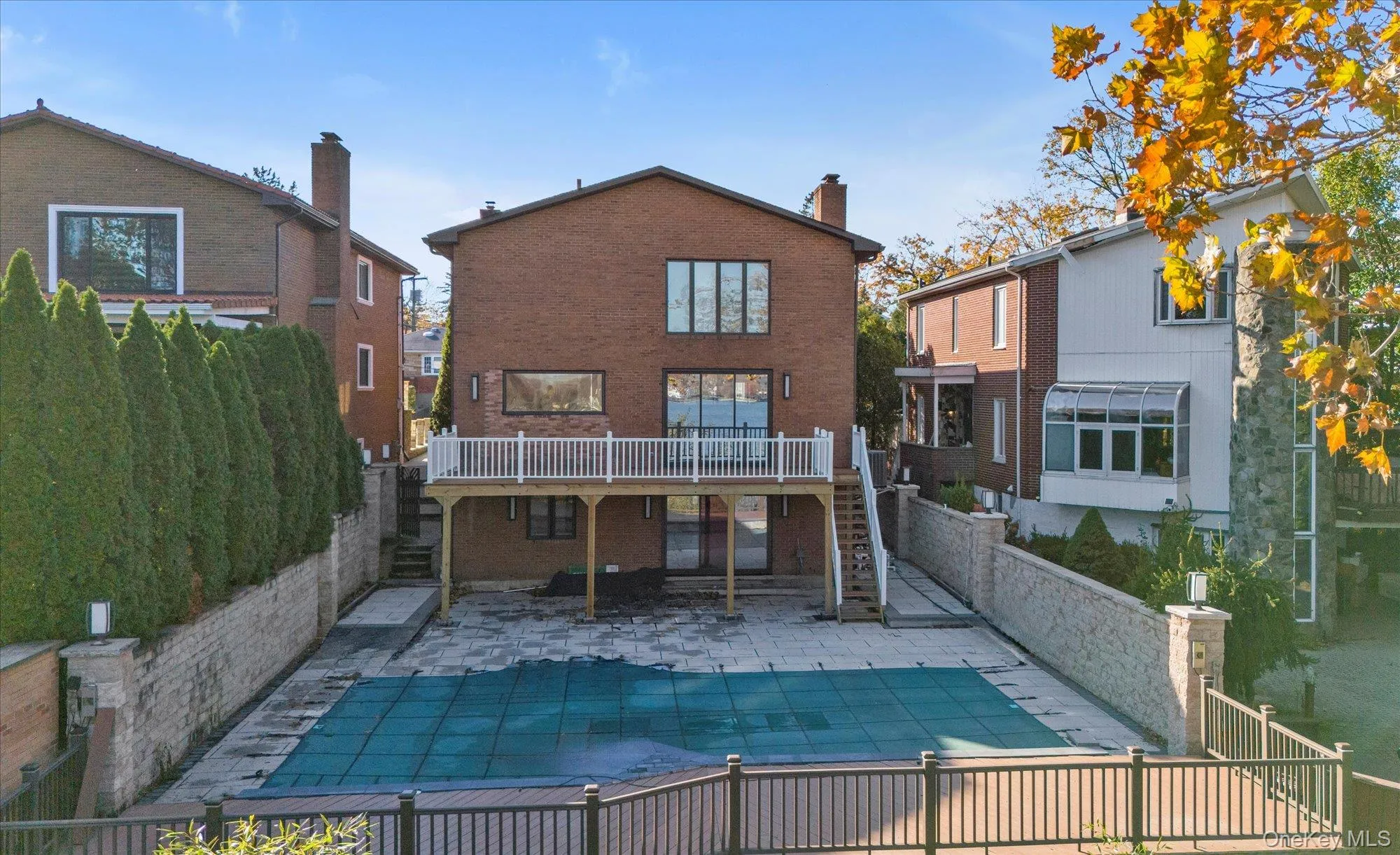 Back of property with stairs, a patio, brick siding, and a chimney Back of property with stairs, a patio, brick siding, and a chimney