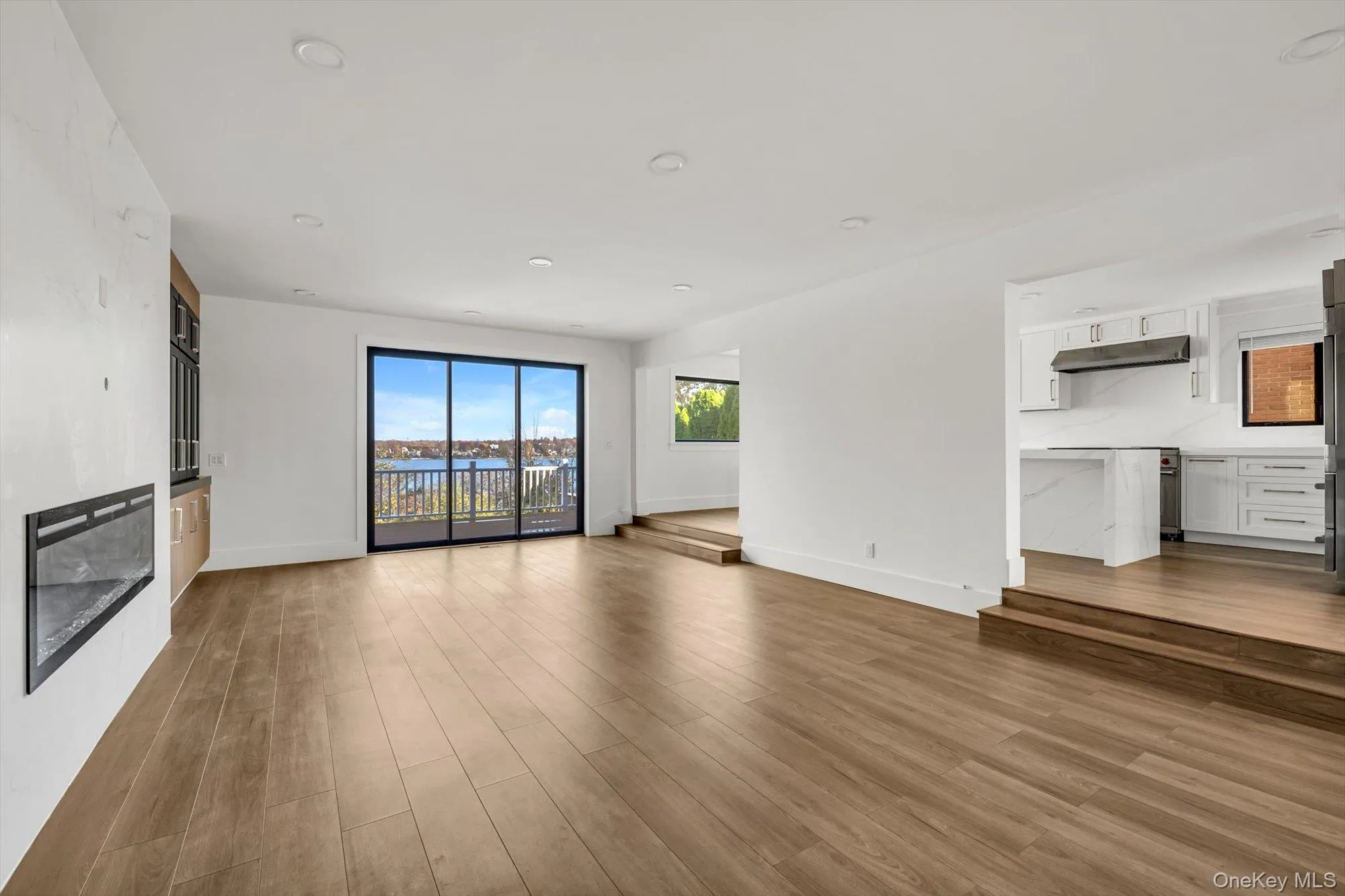 Unfurnished living room featuring recessed lighting and dark wood-type flooring Unfurnished living room featuring recessed lighting and dark wood-type flooring