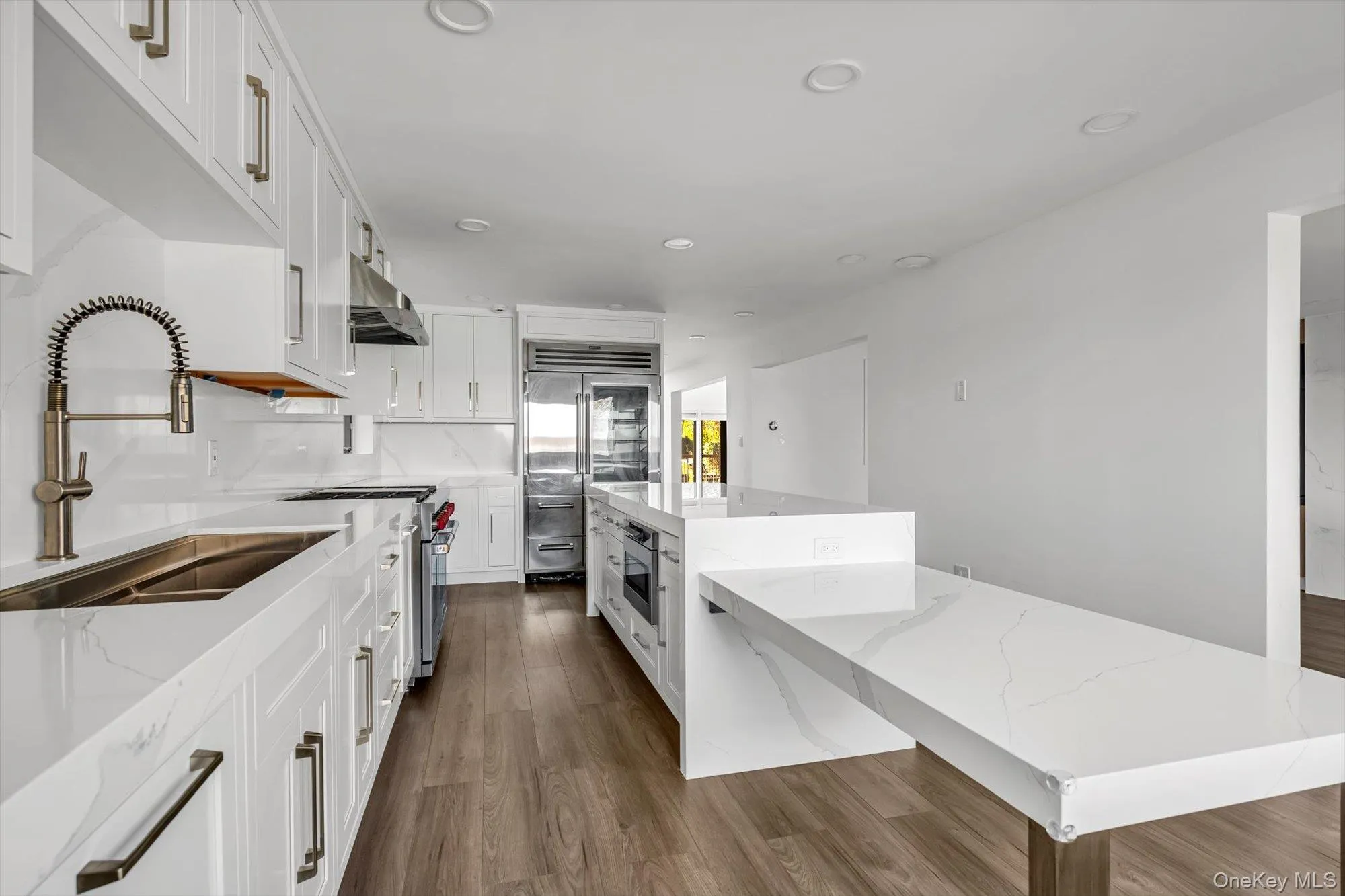 Kitchen featuring white cabinetry, recessed lighting, dark wood-type flooring, light stone countertops, and a kitchen island Kitchen featuring white cabinetry, recessed lighting, dark wood-type flooring, light stone countertops, and a kitchen island