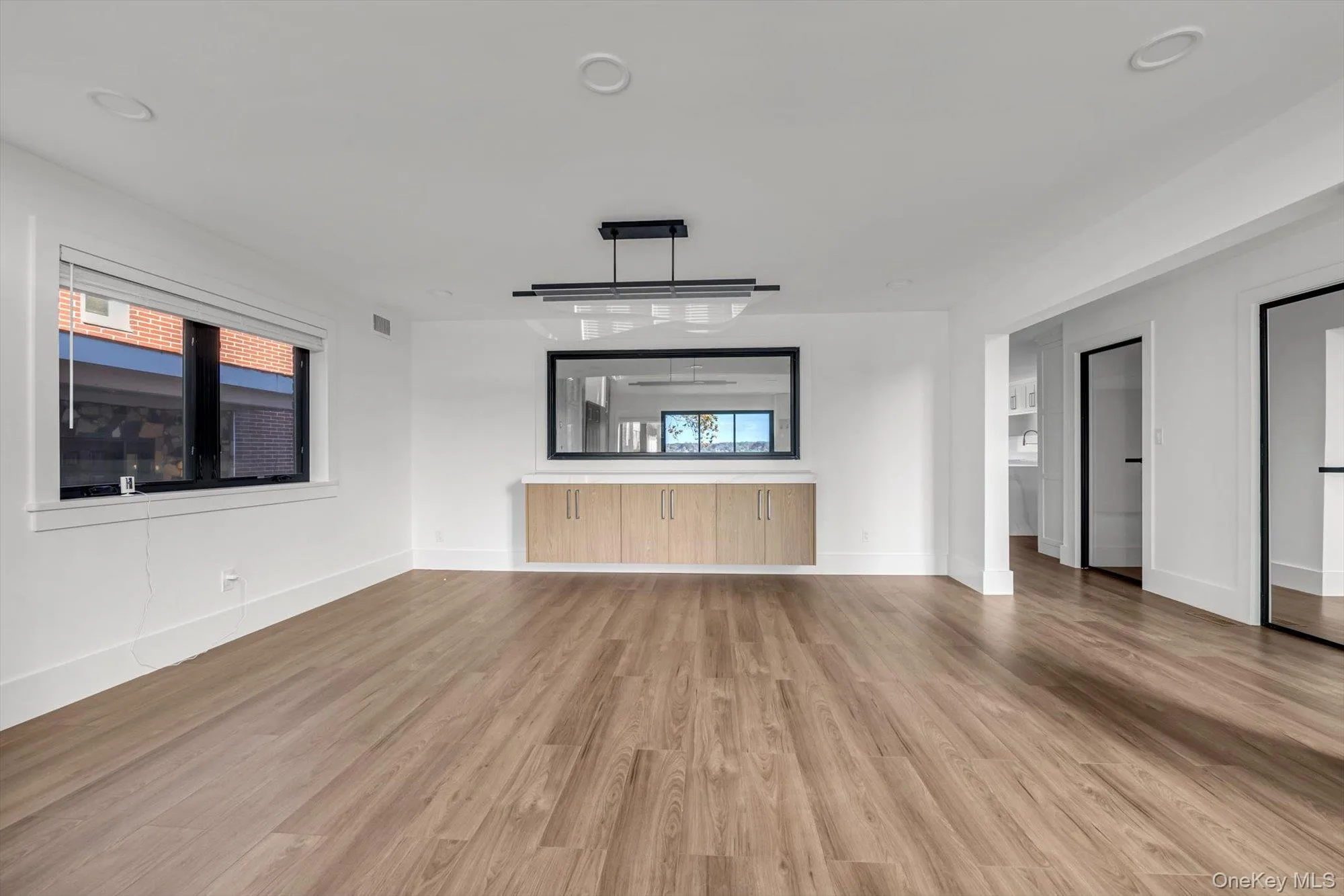 Unfurnished living room featuring light wood-type flooring and recessed lighting Unfurnished living room featuring light wood-type flooring and recessed lighting