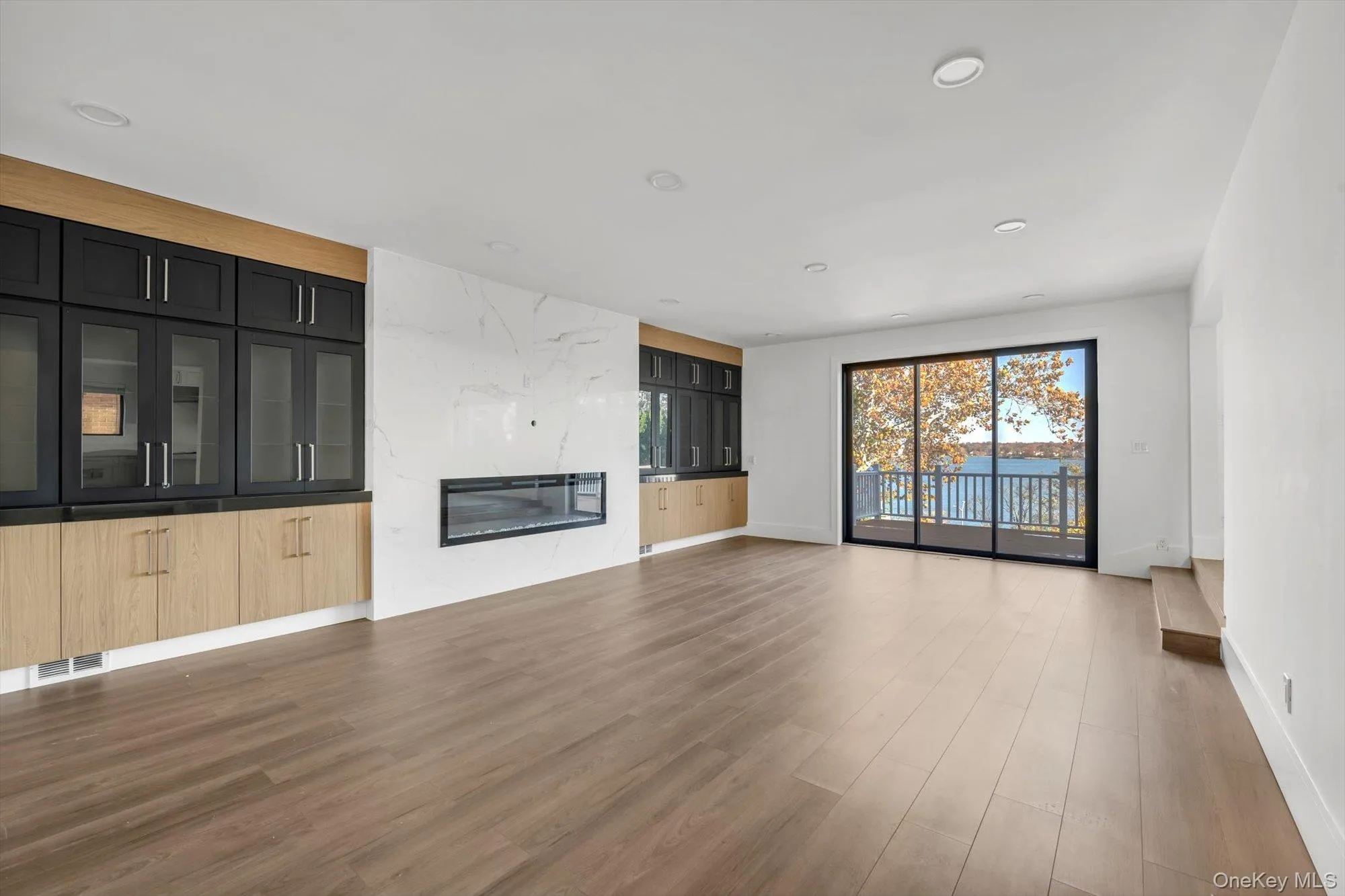 Unfurnished living room featuring a premium fireplace, recessed lighting, and light wood-type flooring Unfurnished living room featuring a premium fireplace, recessed lighting, and light wood-type flooring