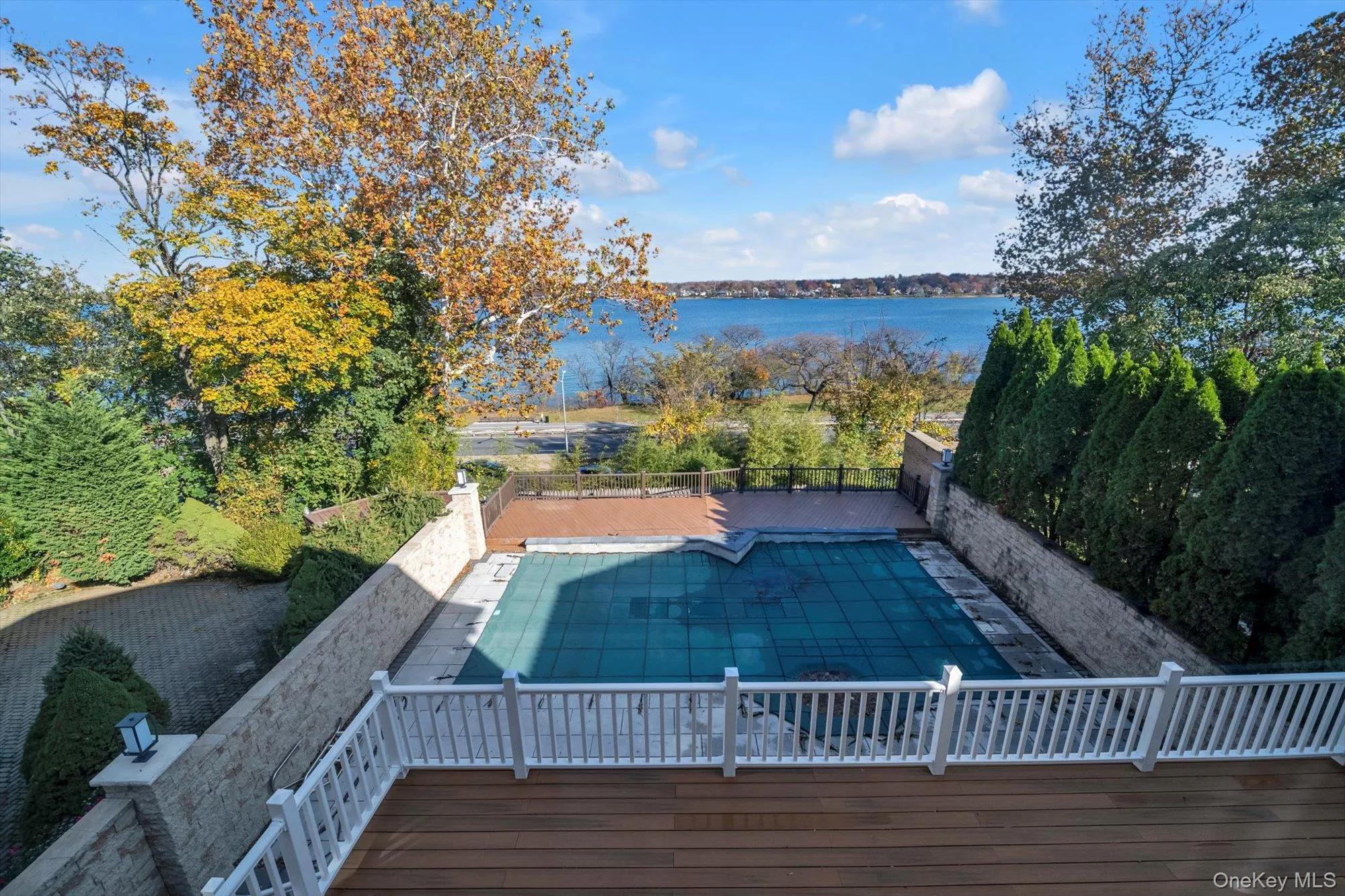View of swimming pool with a water view, a fenced backyard, and a patio View of swimming pool with a water view, a fenced backyard, and a patio